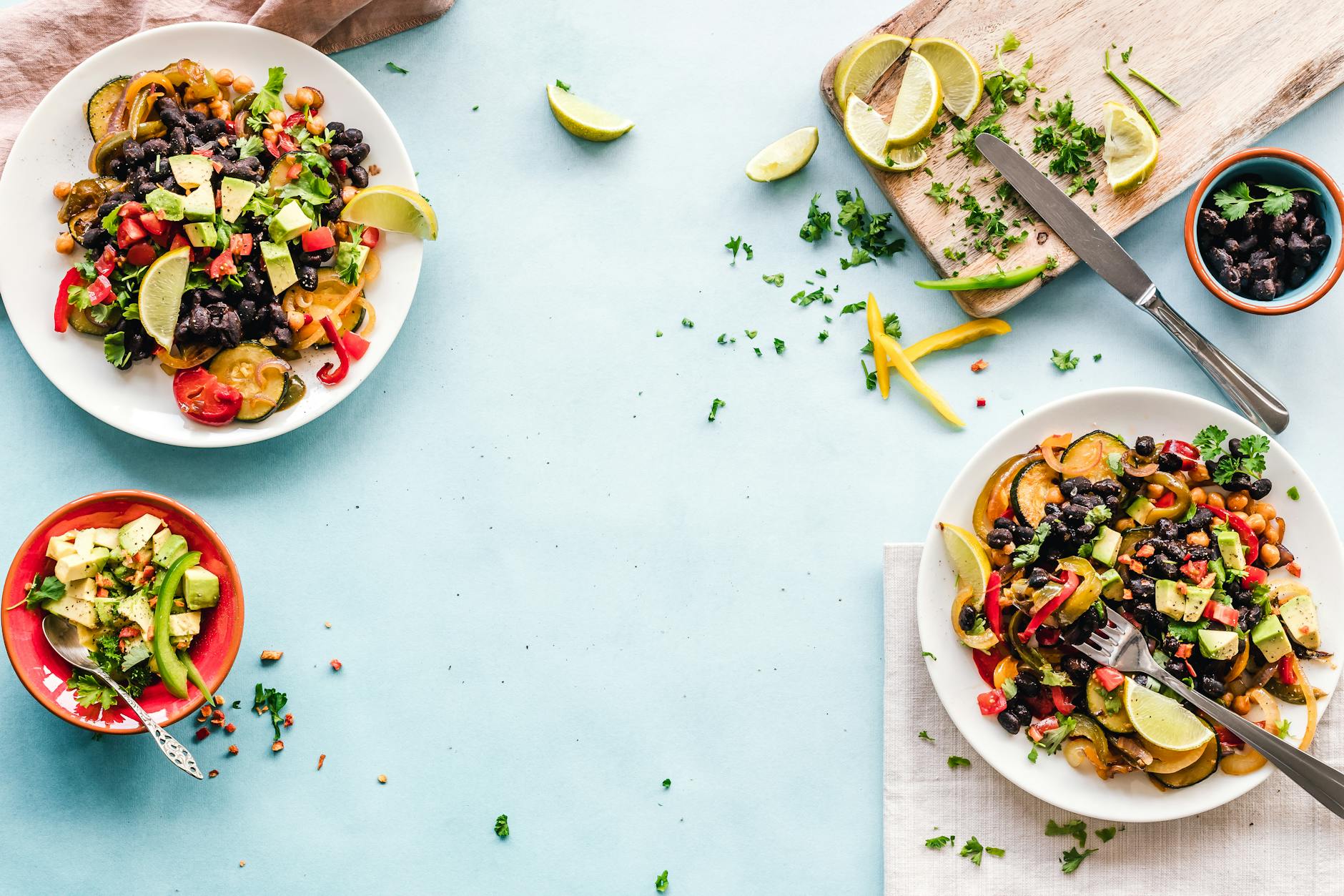 Colorful Mexican salad with avocado, black beans, and lime on a light blue surface. - easy healthy dinners