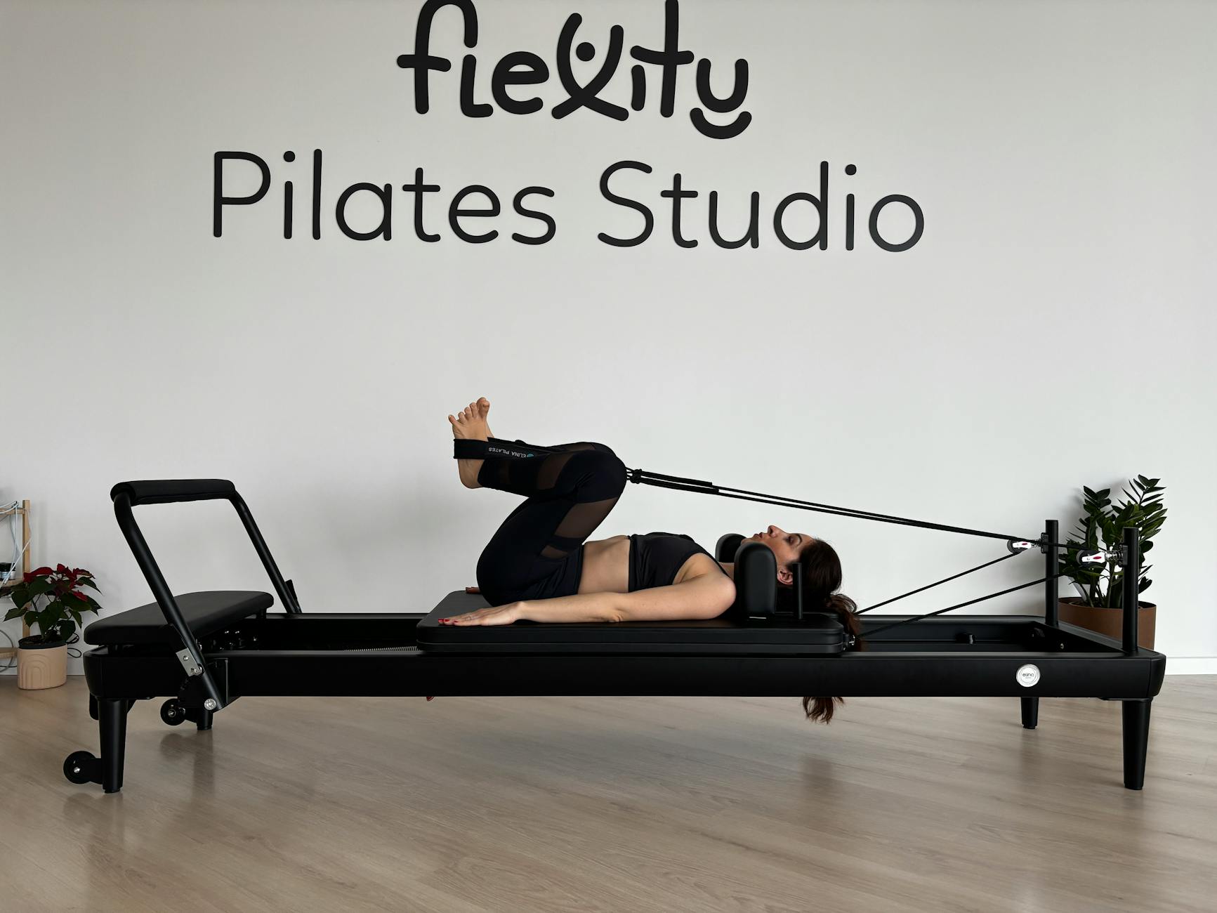 Woman practicing Pilates on a reformer machine in a modern studio setting. - floor pilates exercises