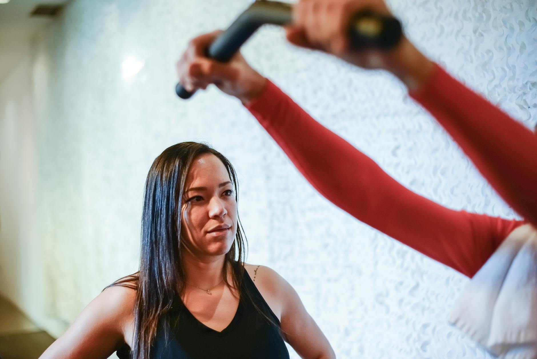 A focused woman receives guidance from a trainer during a gym workout in Portugal. - gym workout plan