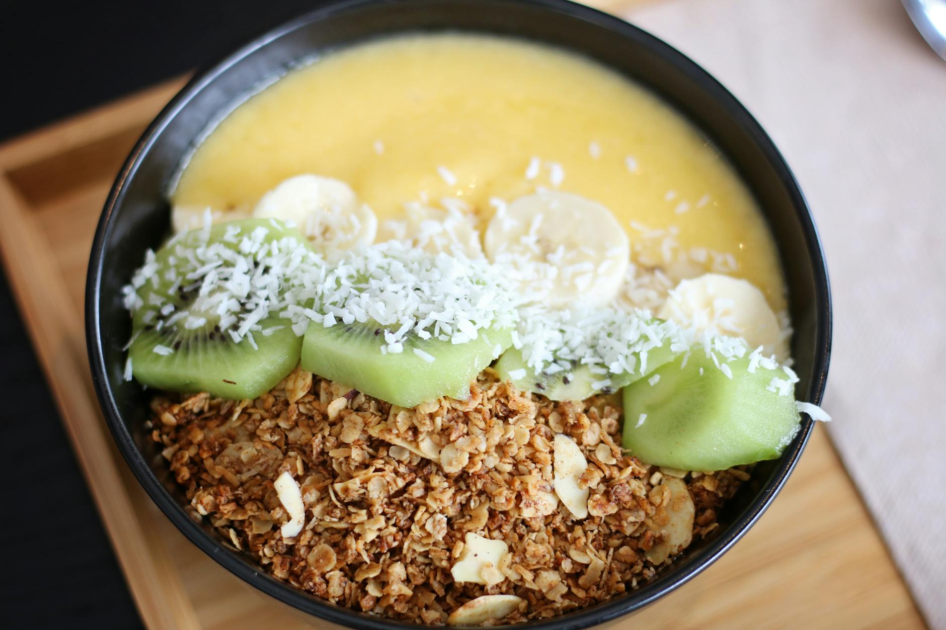 Delicious and nutritious breakfast bowl with kiwi, banana, coconut, and granola. - healthy breakfast ideas