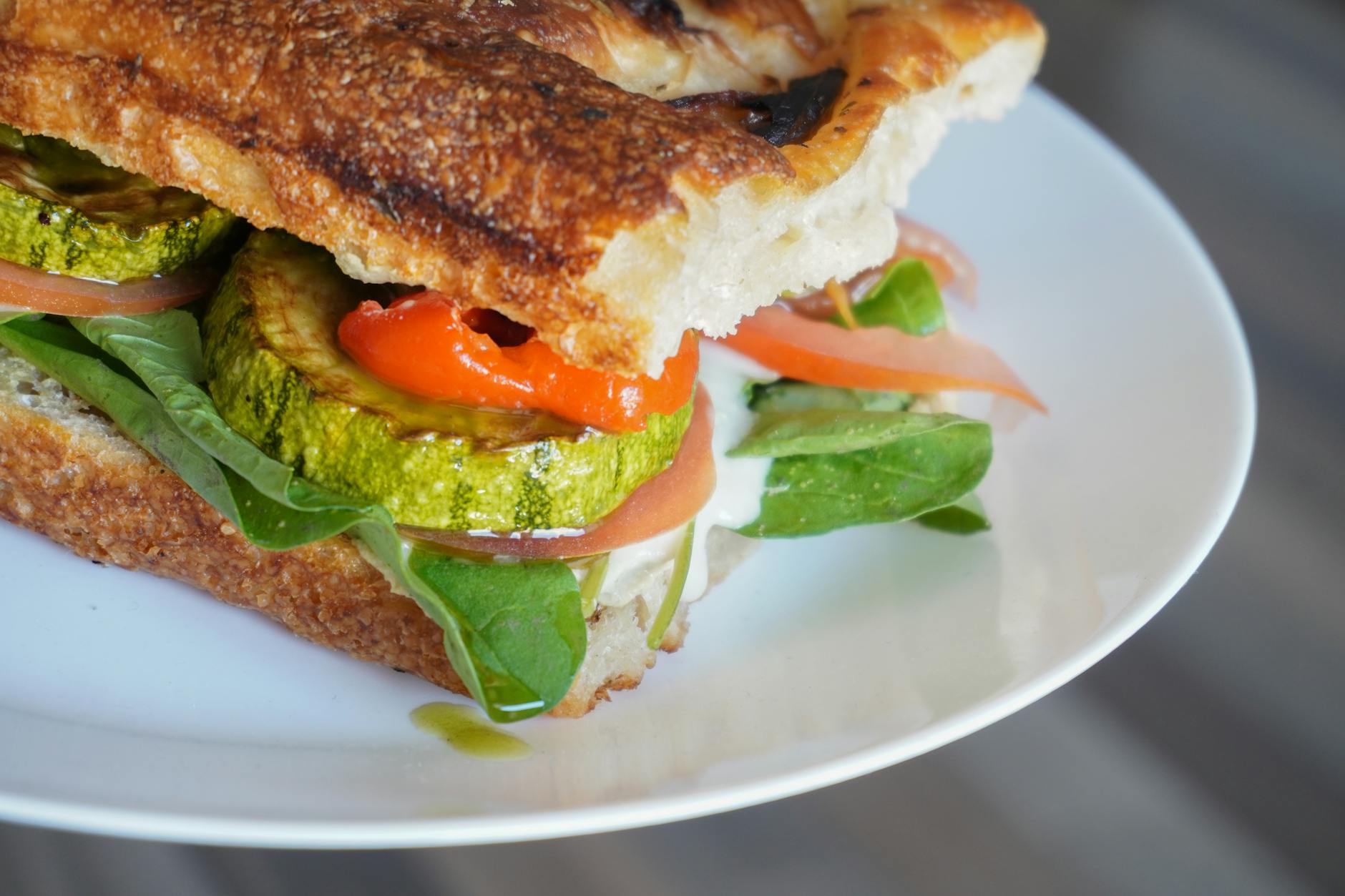 Close-up of a mouthwatering vegetarian sandwich with fresh vegetables and grilled zucchini. - healthy breakfast sandwich