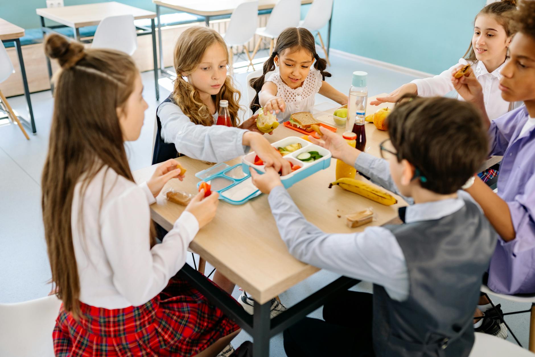 Group of diverse children having lunch in a school canteen, sharing and enjoying healthy snacks. - healthy kids lunches