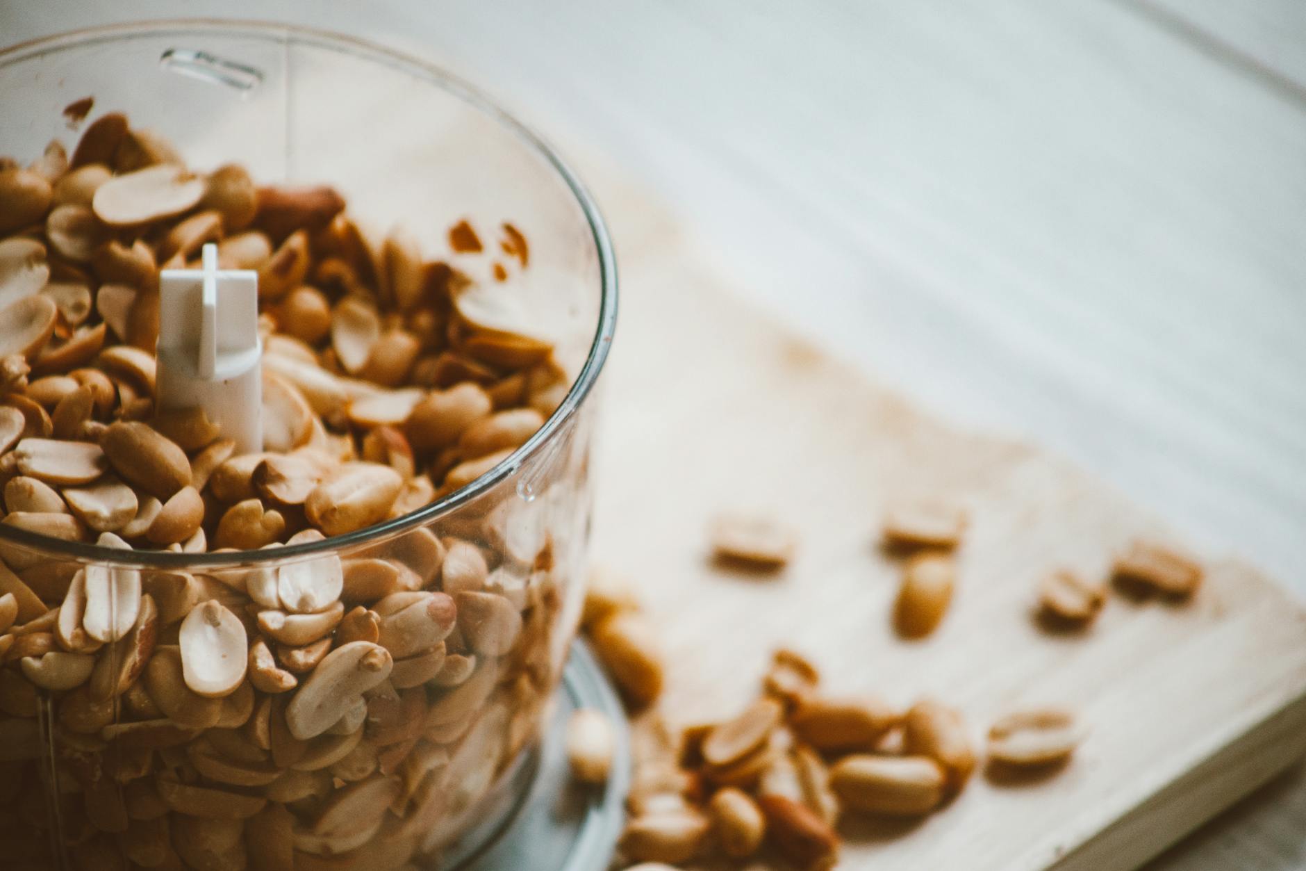 A detailed shot of peanuts in a blender jar, ready for processing. - healthy peanut butter snacks