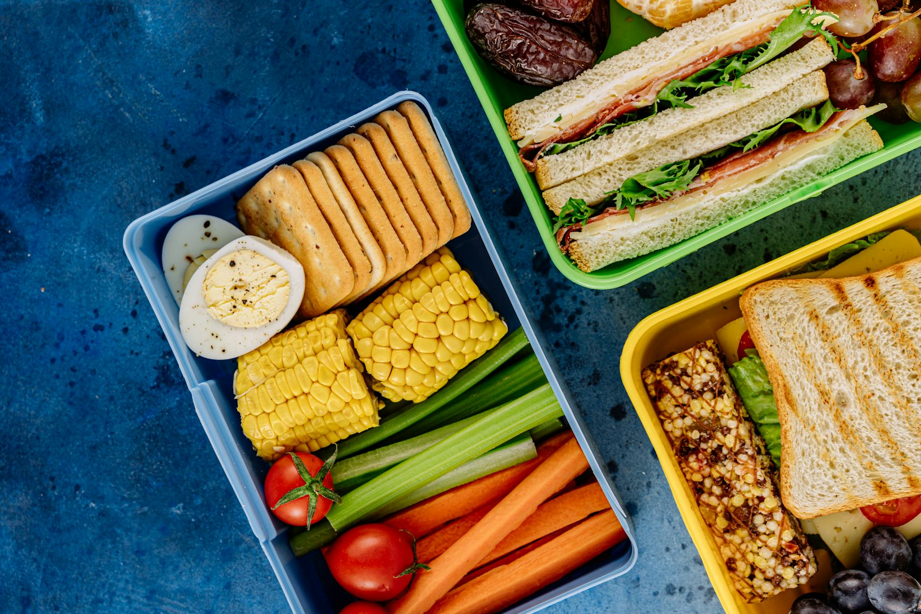 Colorful lunchboxes featuring sandwiches, vegetables, and snacks for healthy eating. - healthy school lunches