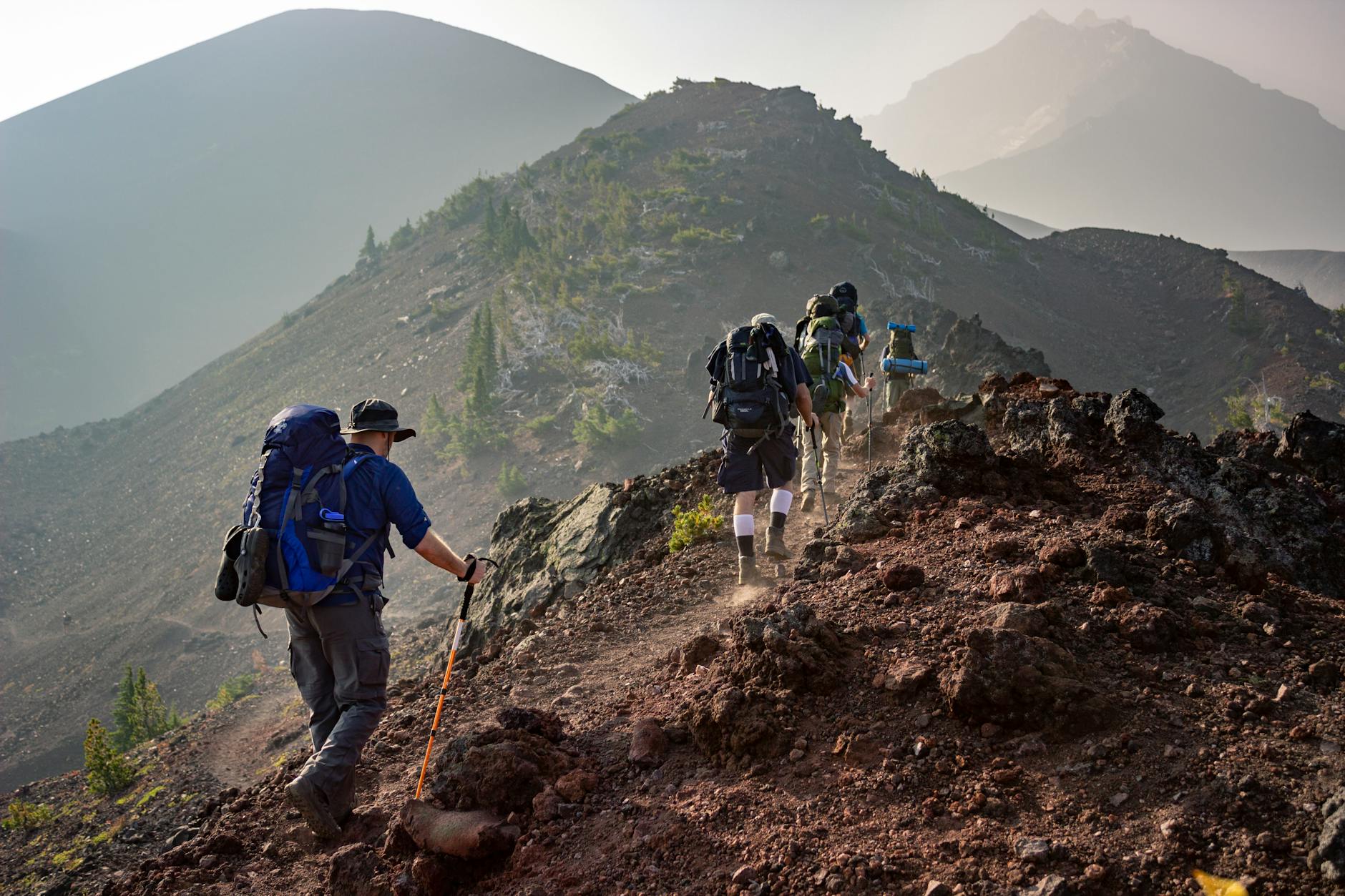 Group of hikers trekking on a rugged mountain trail in Oregon's scenic outdoors. - hiking for weight loss