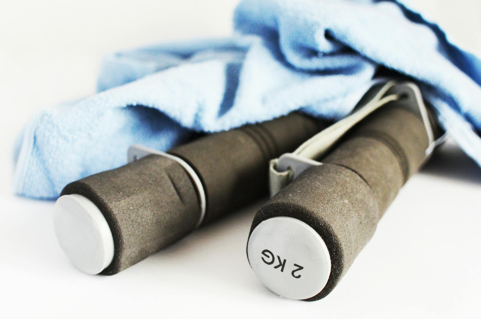 Close-up of 2kg dumbbells and a towel, perfect for a fitness routine or gym workout. - home cardio workout
