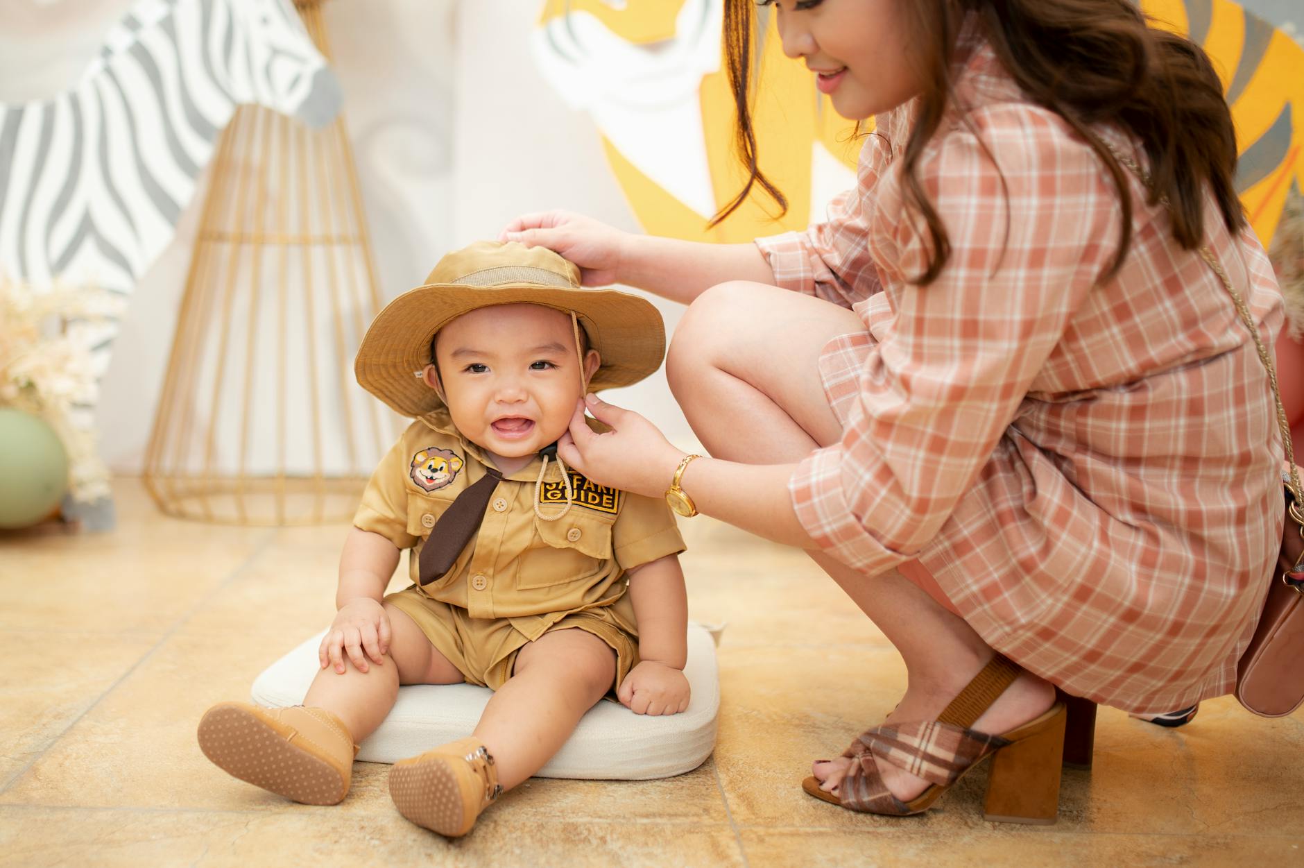 A cute toddler dressed as a safari guide sitting indoors during a playful photoshoot with his mother. - intermittent fasting guide