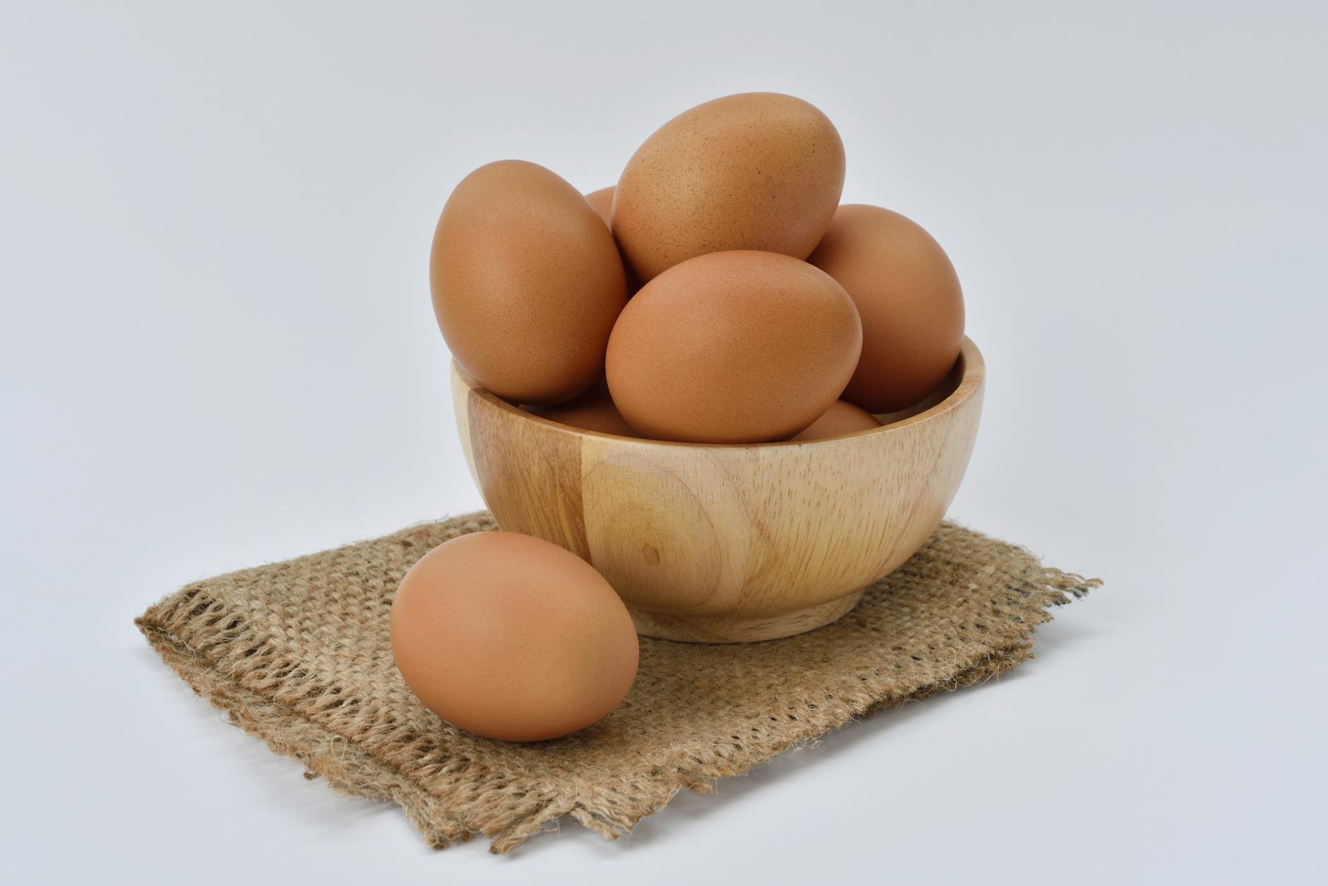 High resolution image of brown eggs in a wooden bowl placed on burlap fabric, ideal for food-themed content. - what is keto diet
