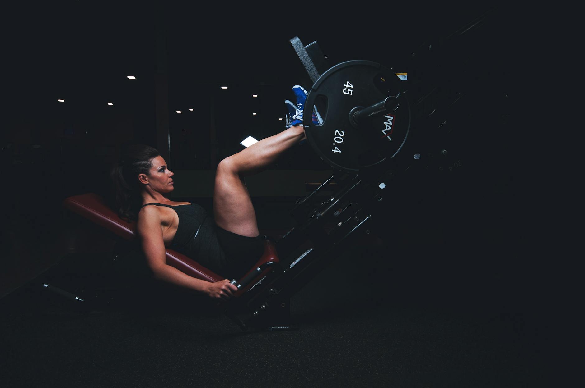 A woman engages in an intense leg press workout at the gym, showcasing strength and fitness. - leg workout routine