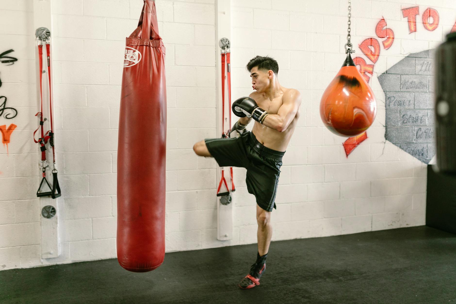 Fit man practicing kickboxing and strength training at a gym. Energetic workout. - lower body exercises