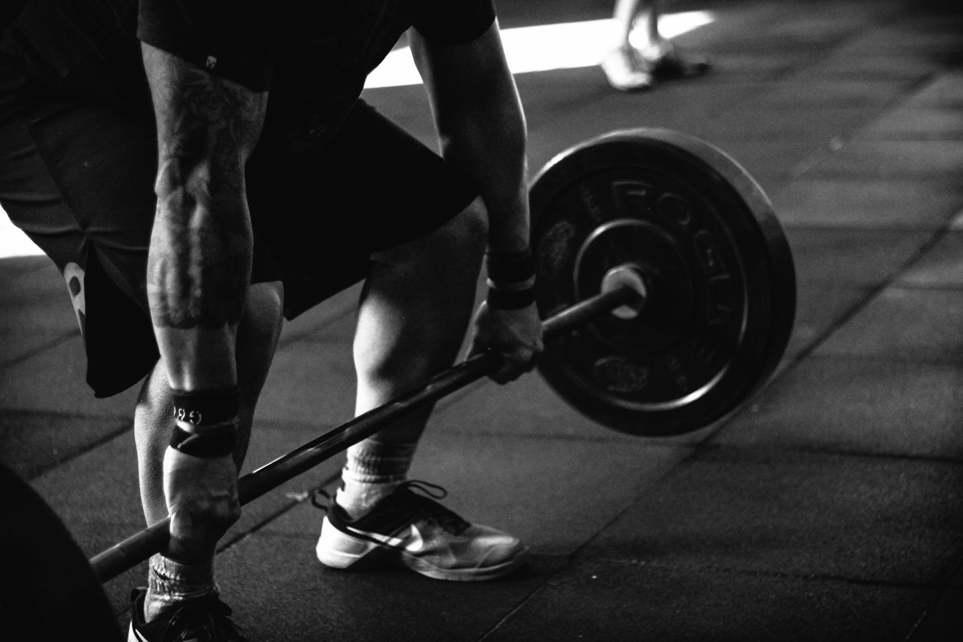 A powerful black and white image of a man deadlifting in a gym, showcasing strength and fitness. - maintain weight travel