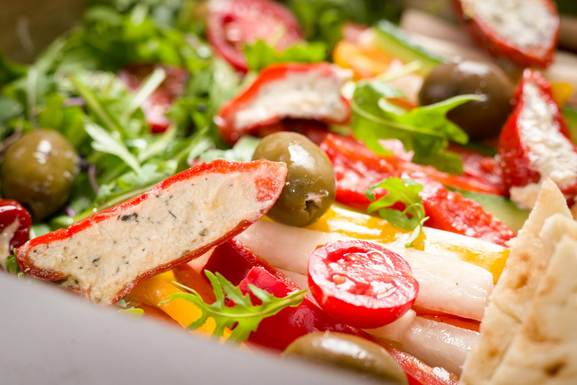 Colorful Mediterranean salad featuring stuffed peppers, olives, and fresh greens. - mediterranean salad recipe