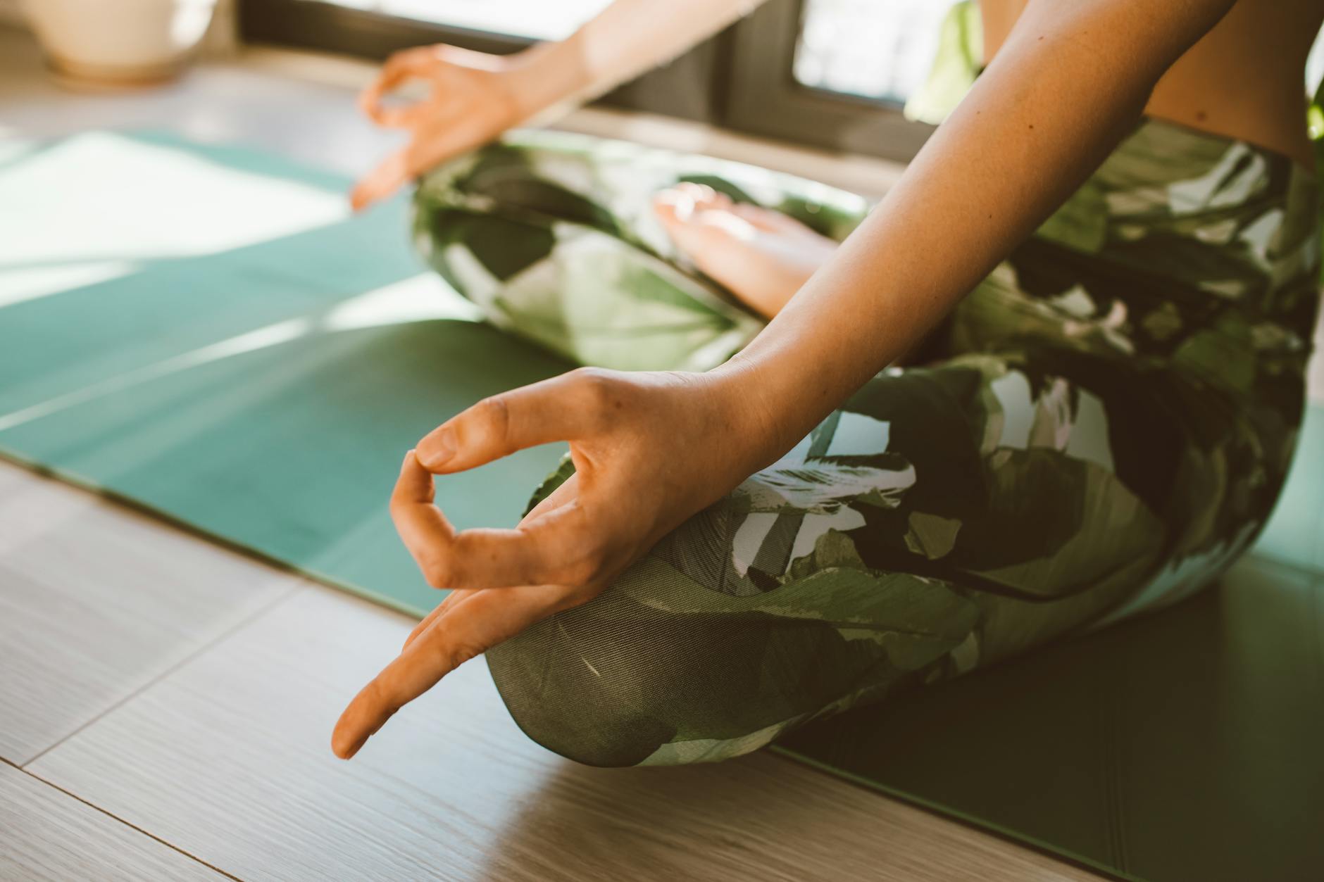 Serene close-up of woman practicing yoga on a mat indoors in natural light. - mental wellness practices