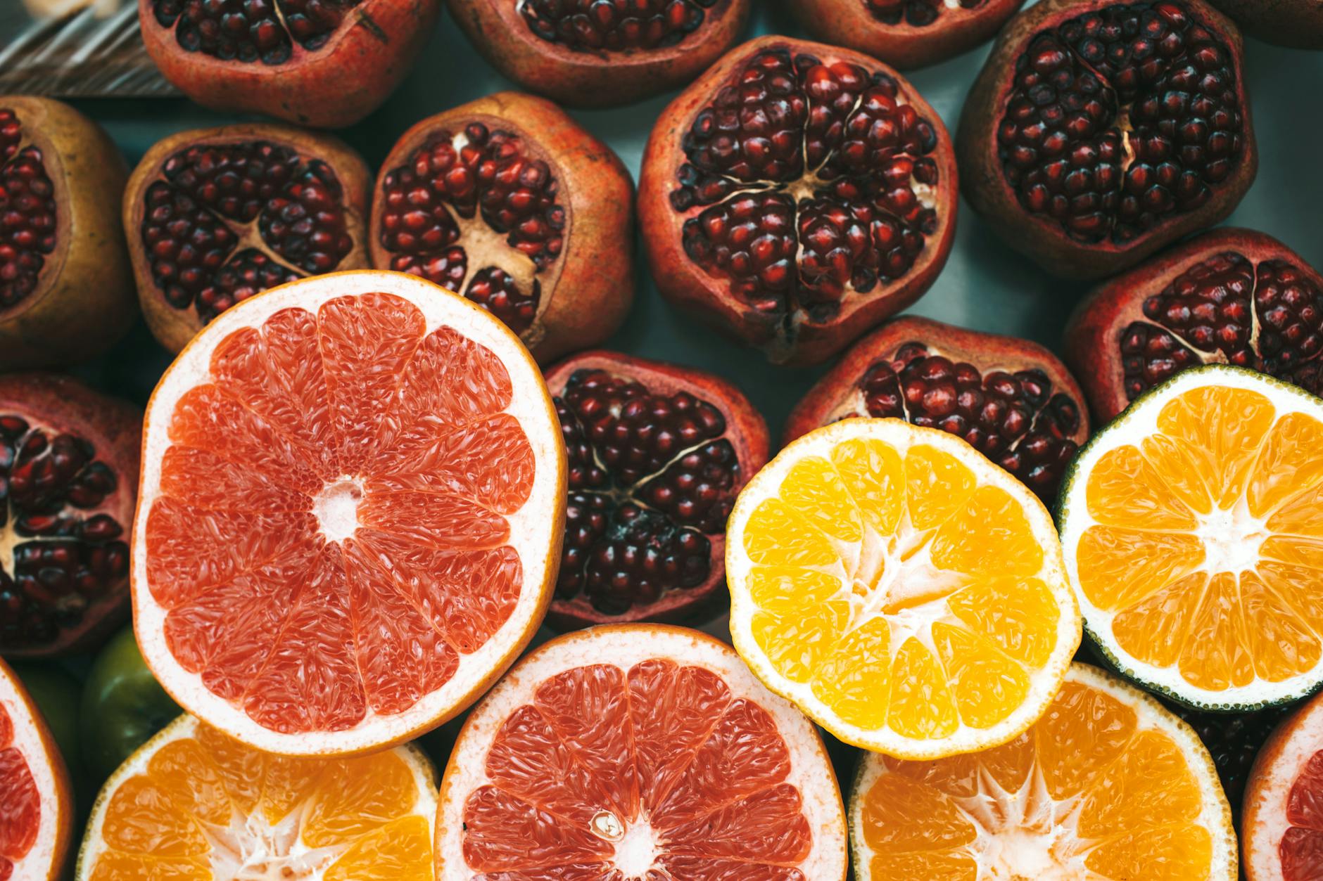 Close-up view of colorful sliced citrus fruits and pomegranates showcasing freshness and nutrition. - natural immune support