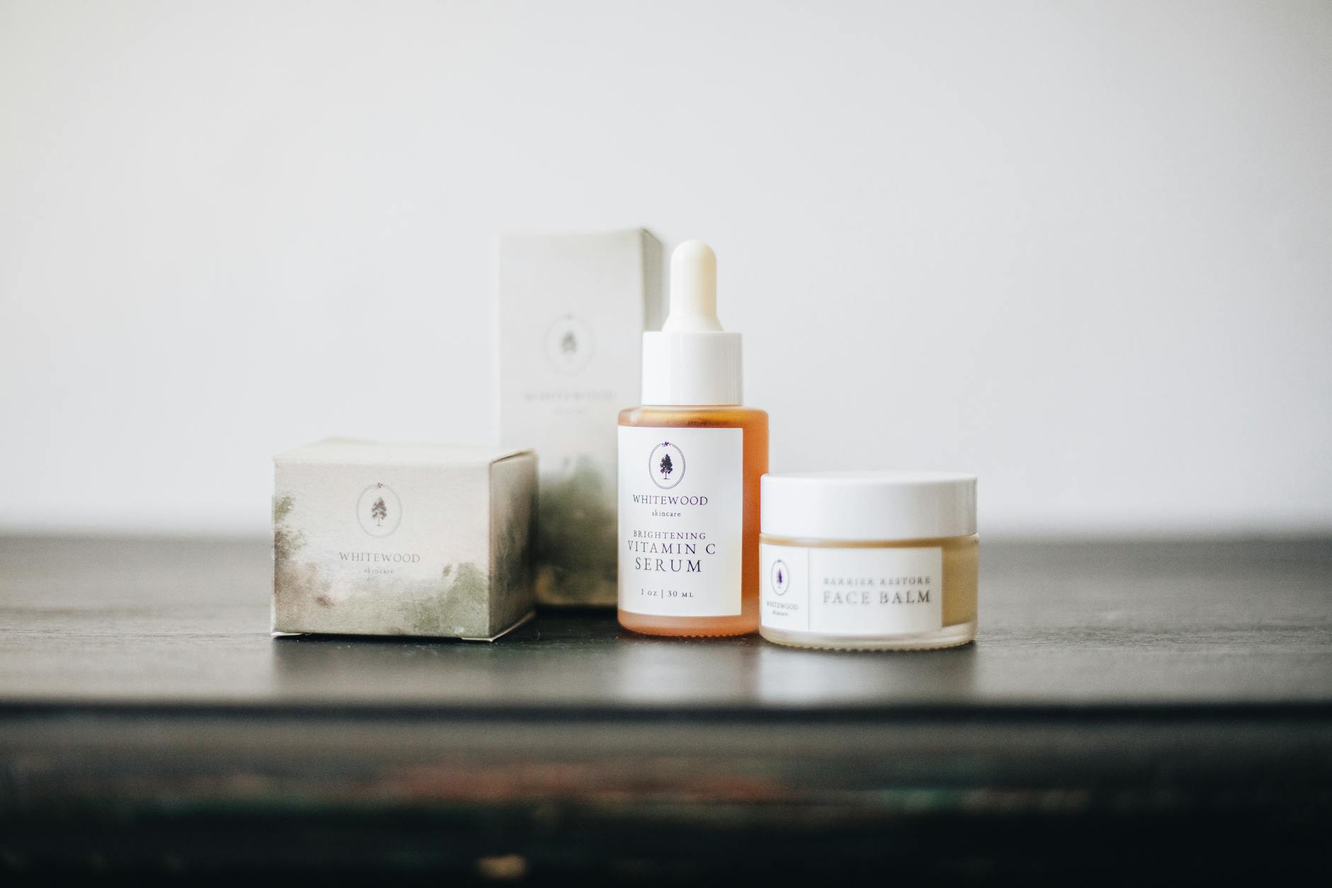 Elegant flat lay of natural skincare products, featuring a vitamin C serum and face balm. - natural skincare routine steps