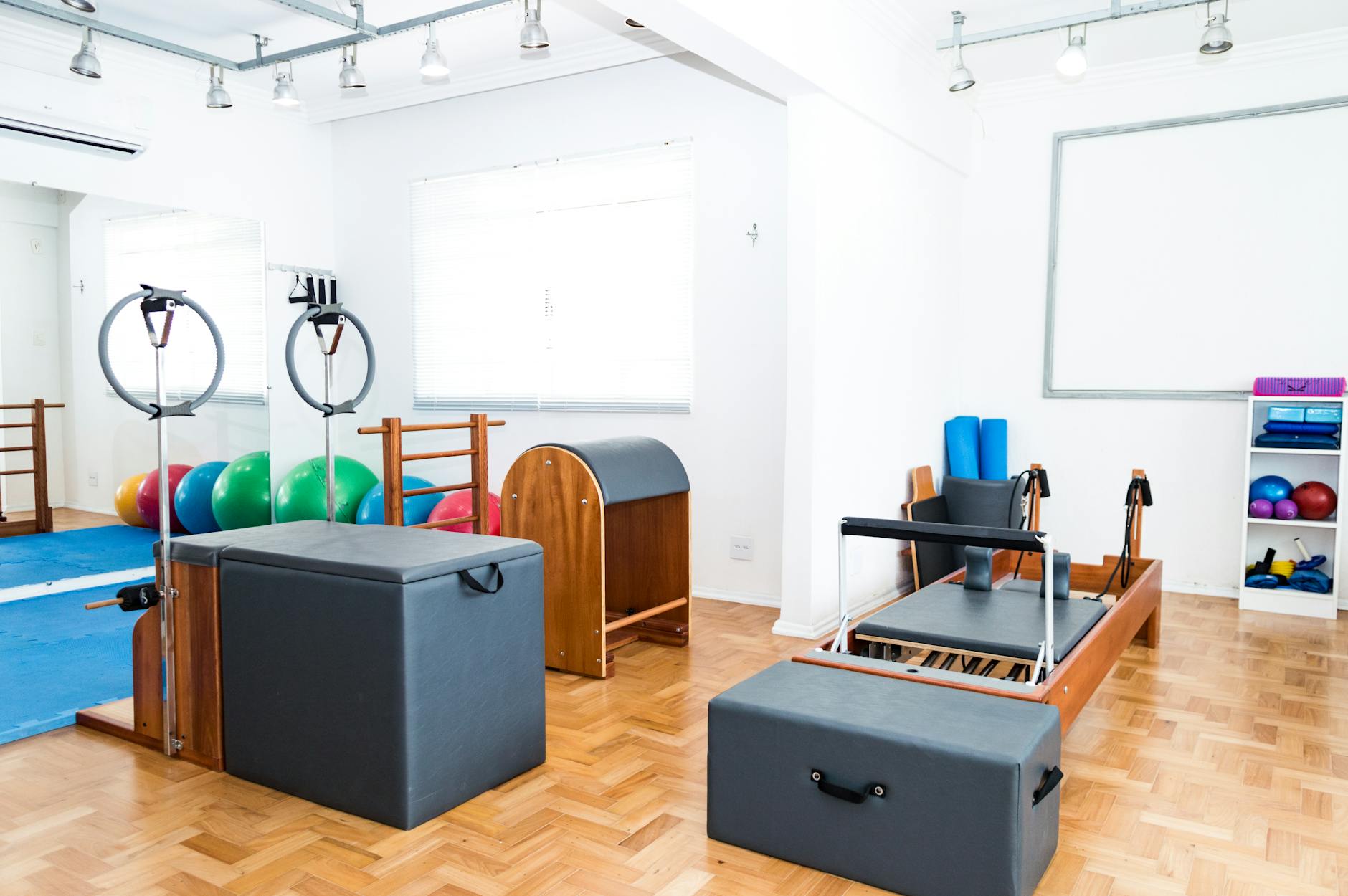 Spacious Pilates studio with modern equipment and vibrant exercise balls. - pilates mat exercises