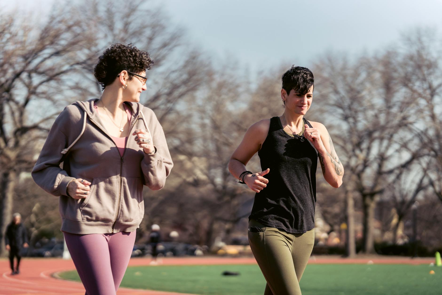 Two women jogging on an outdoor track, enjoying a sunny day and healthy lifestyle. - running for women