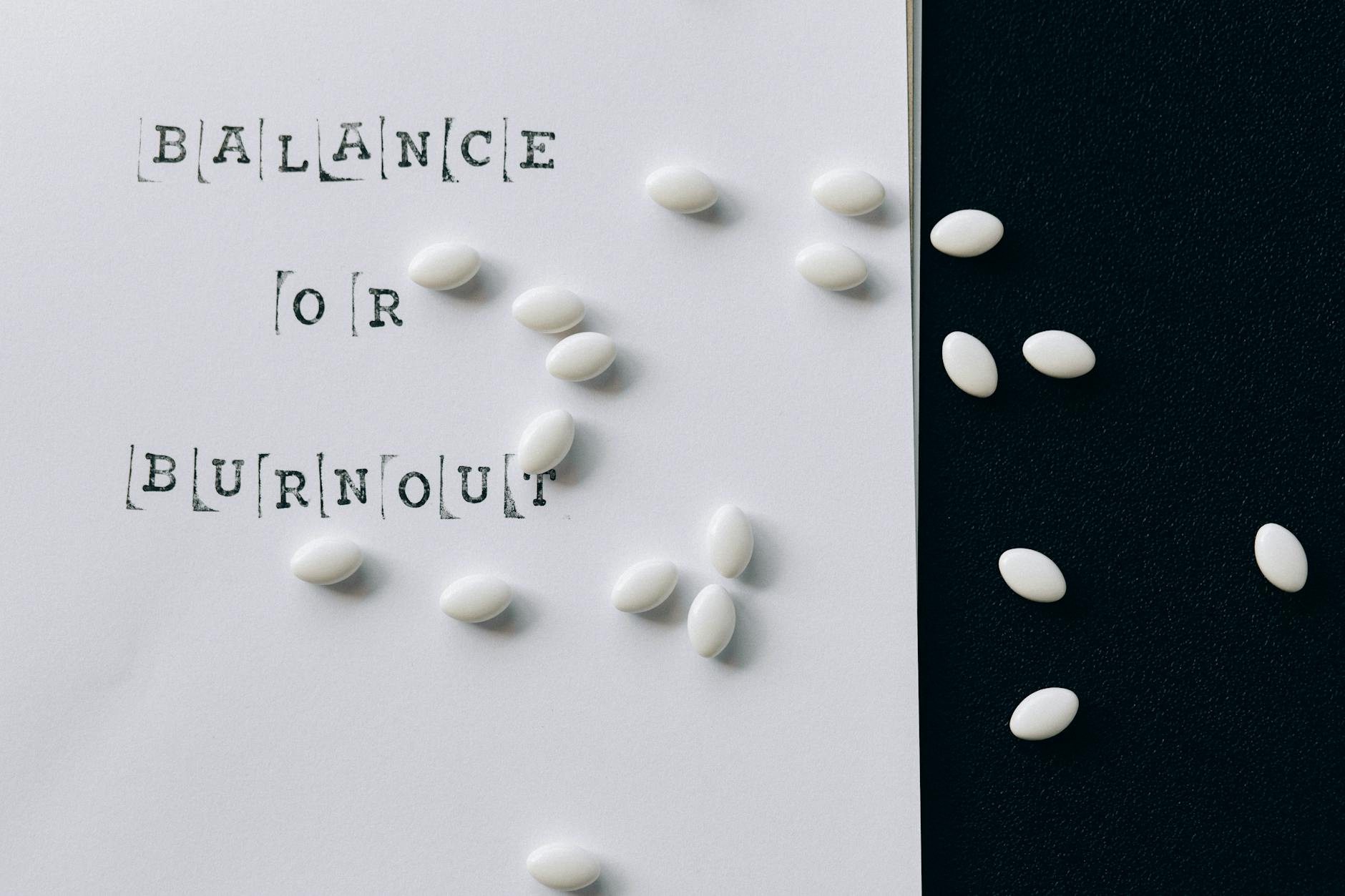Conceptual image featuring 'Balance or Burnout' text with scattered white capsules. - spring mindfulness stress