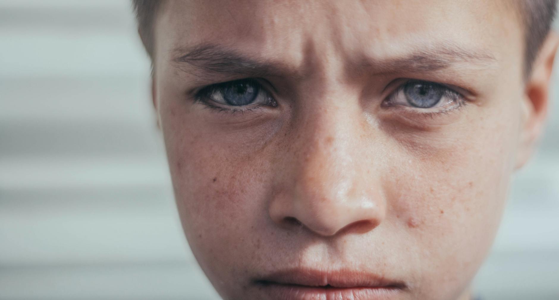 Intense close-up of a young boy's face expressing deep emotion. - spring sad science