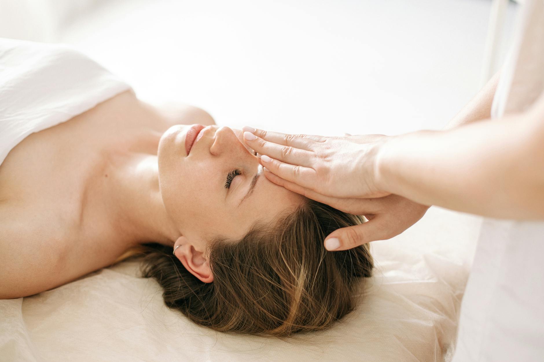 Woman enjoying a peaceful head massage in a serene spa environment. - spring skin care