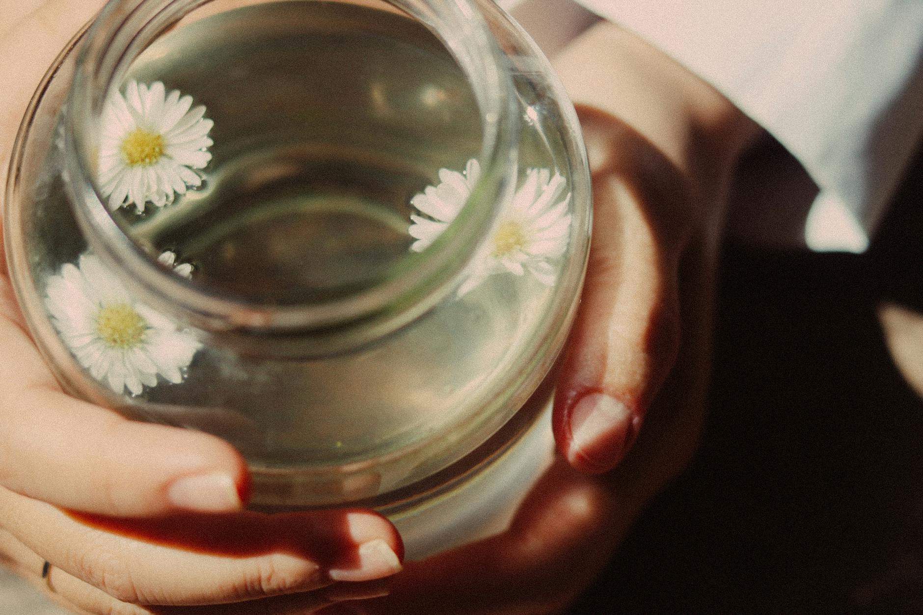 A close-up of a serene floral tea held gently in hands, promoting relaxation. - spring wellness rituals
