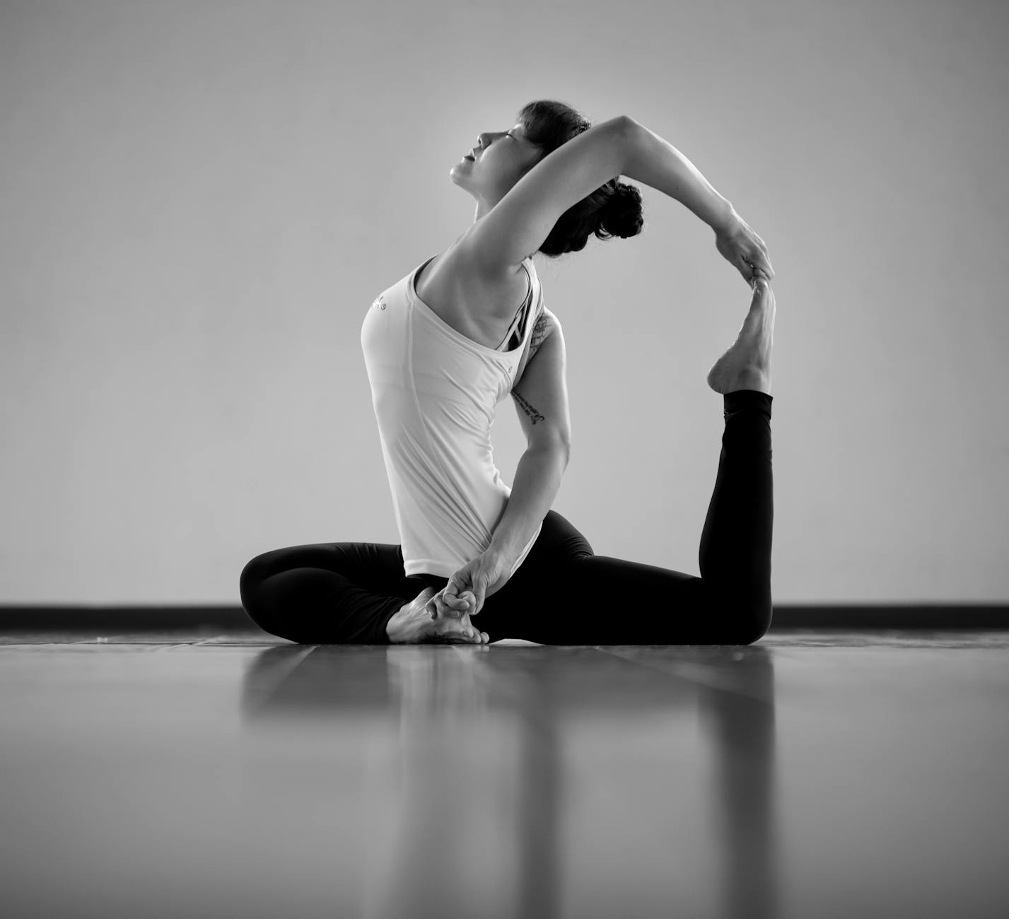 Adult woman demonstrating flexibility in a yoga pose indoors. - spring yoga flow
