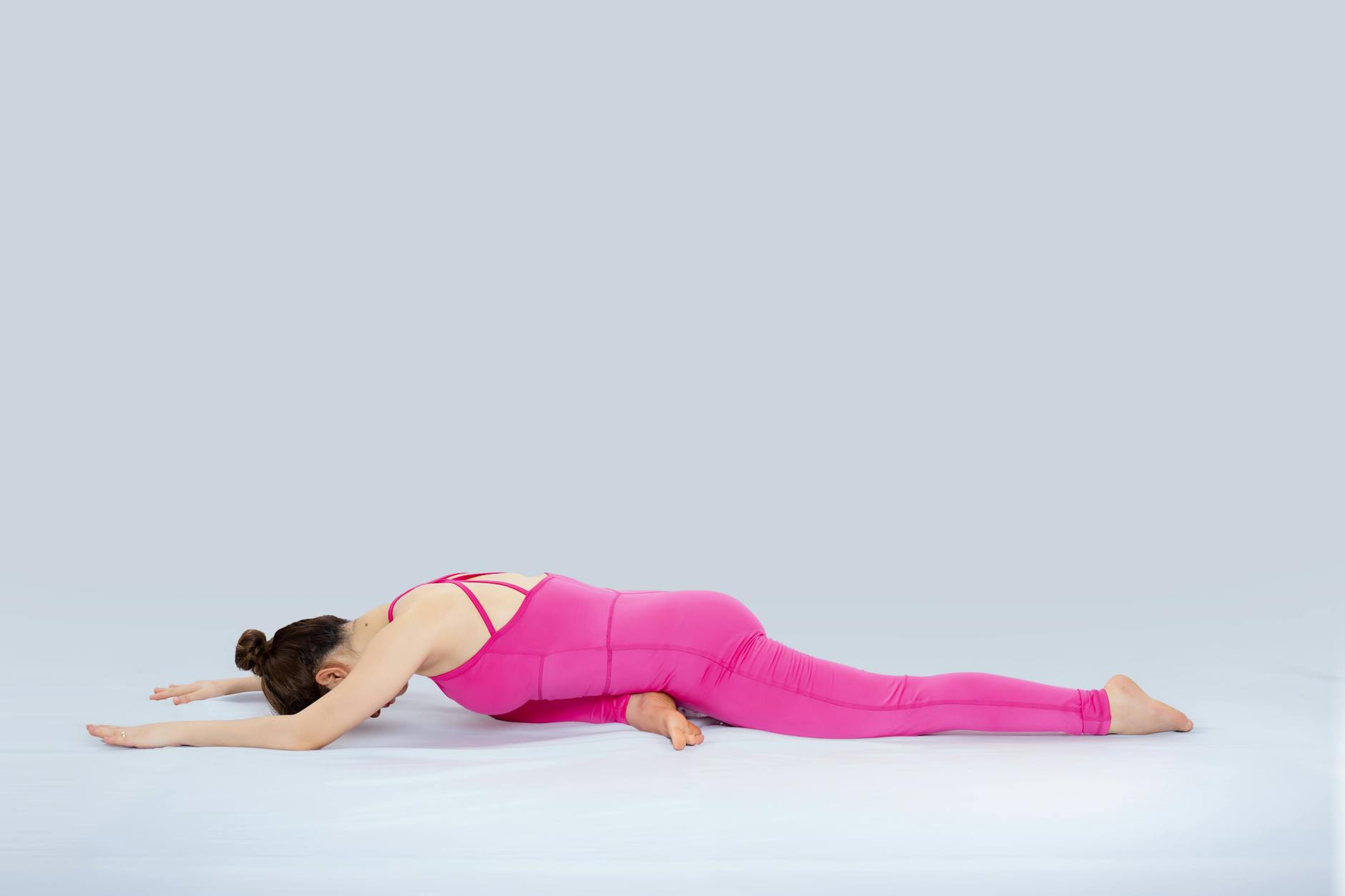 Female practicing yoga in pink attire on a mat. Indoor serene setting. - spring yoga poses