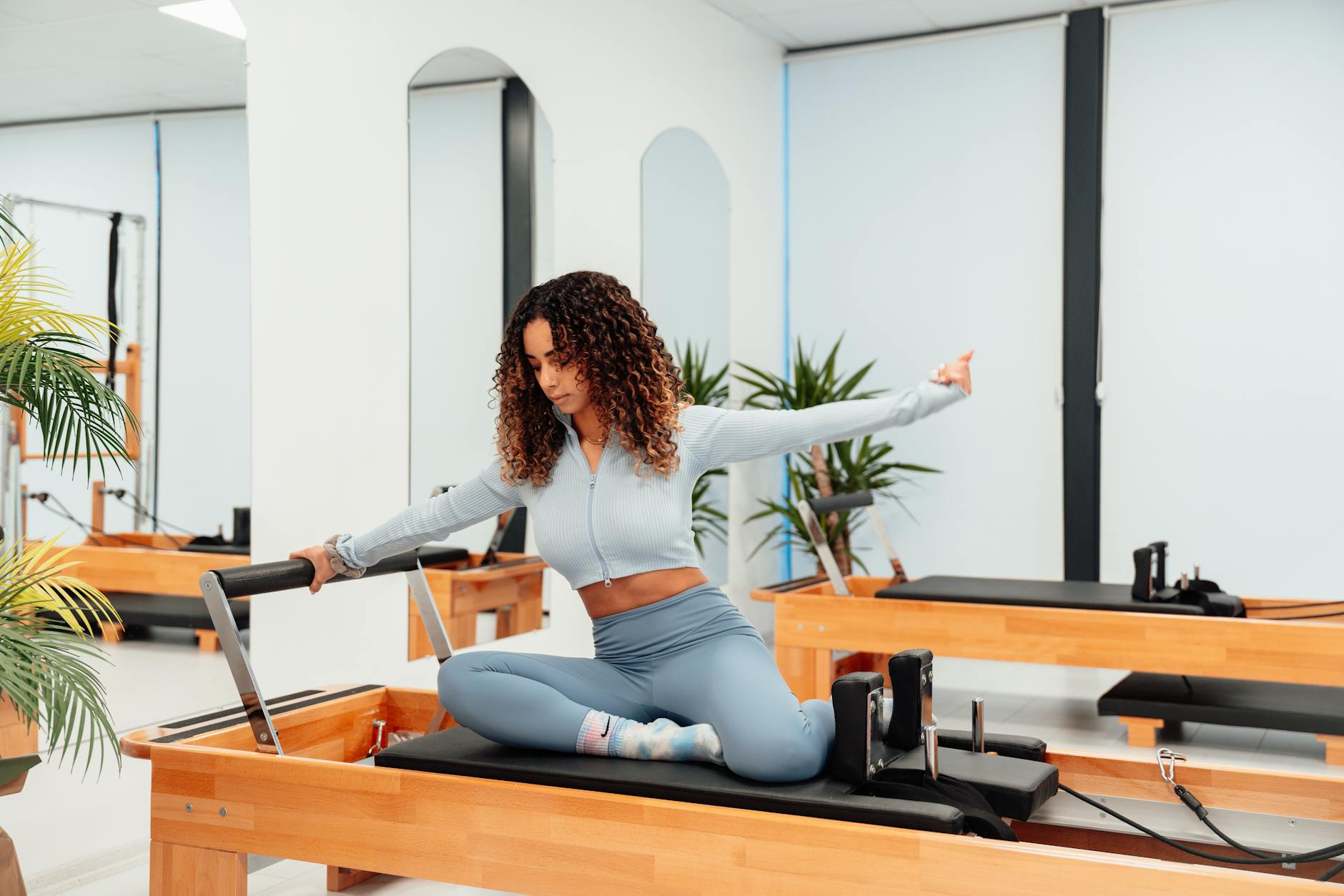 A woman exercising on a reformer in a pilates studio, embodying a healthy lifestyle. - standing pilates