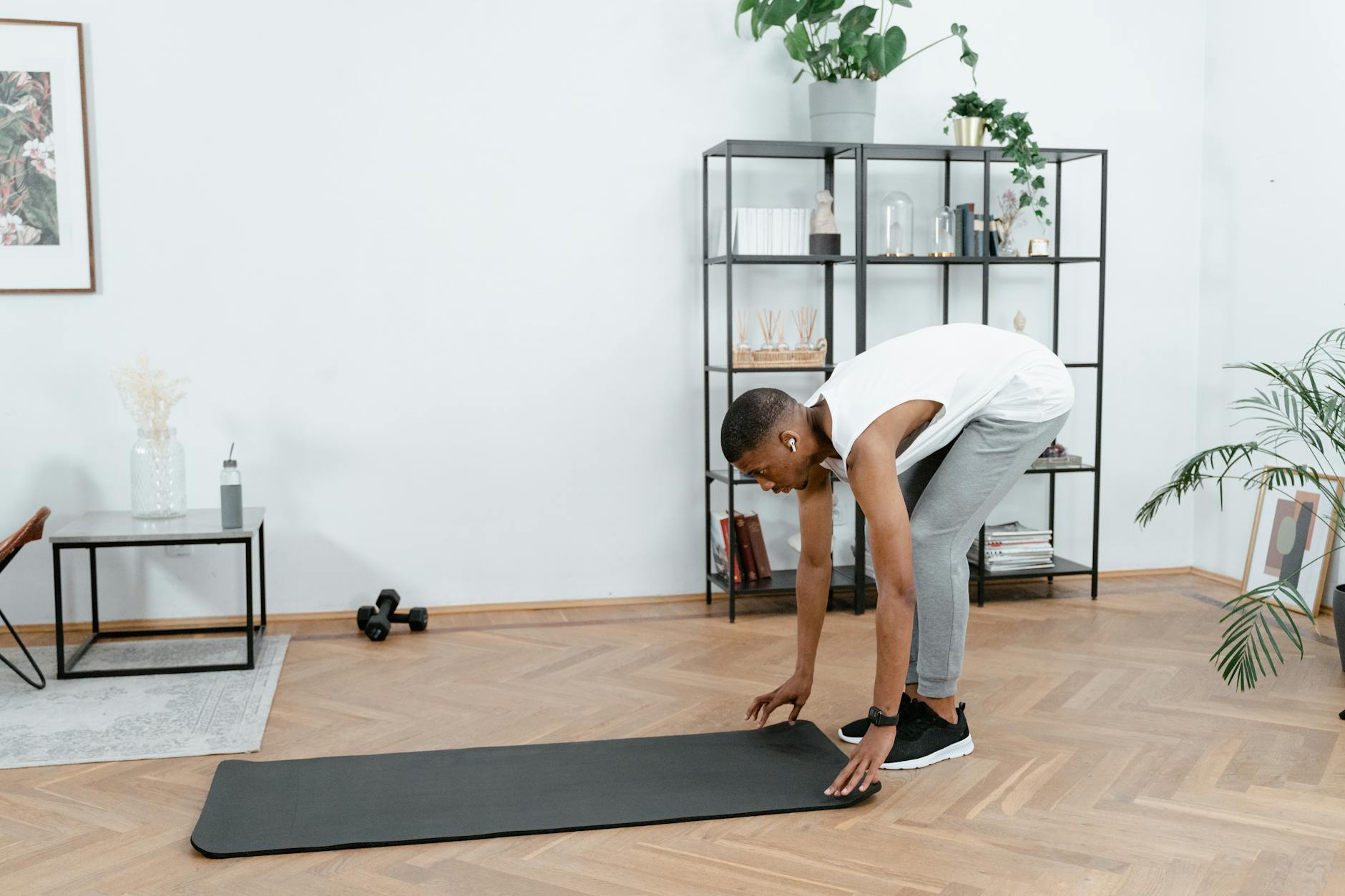 Black man practicing yoga indoors with mat, promoting healthy lifestyle and body care. - stretching routine men