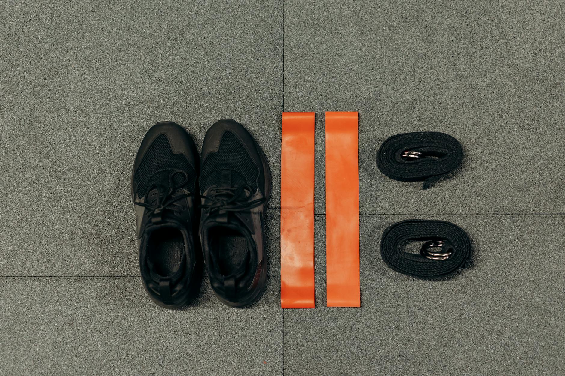 Flat lay of fitness essentials: sneakers, resistance bands, and straps for training. - walk for weight loss