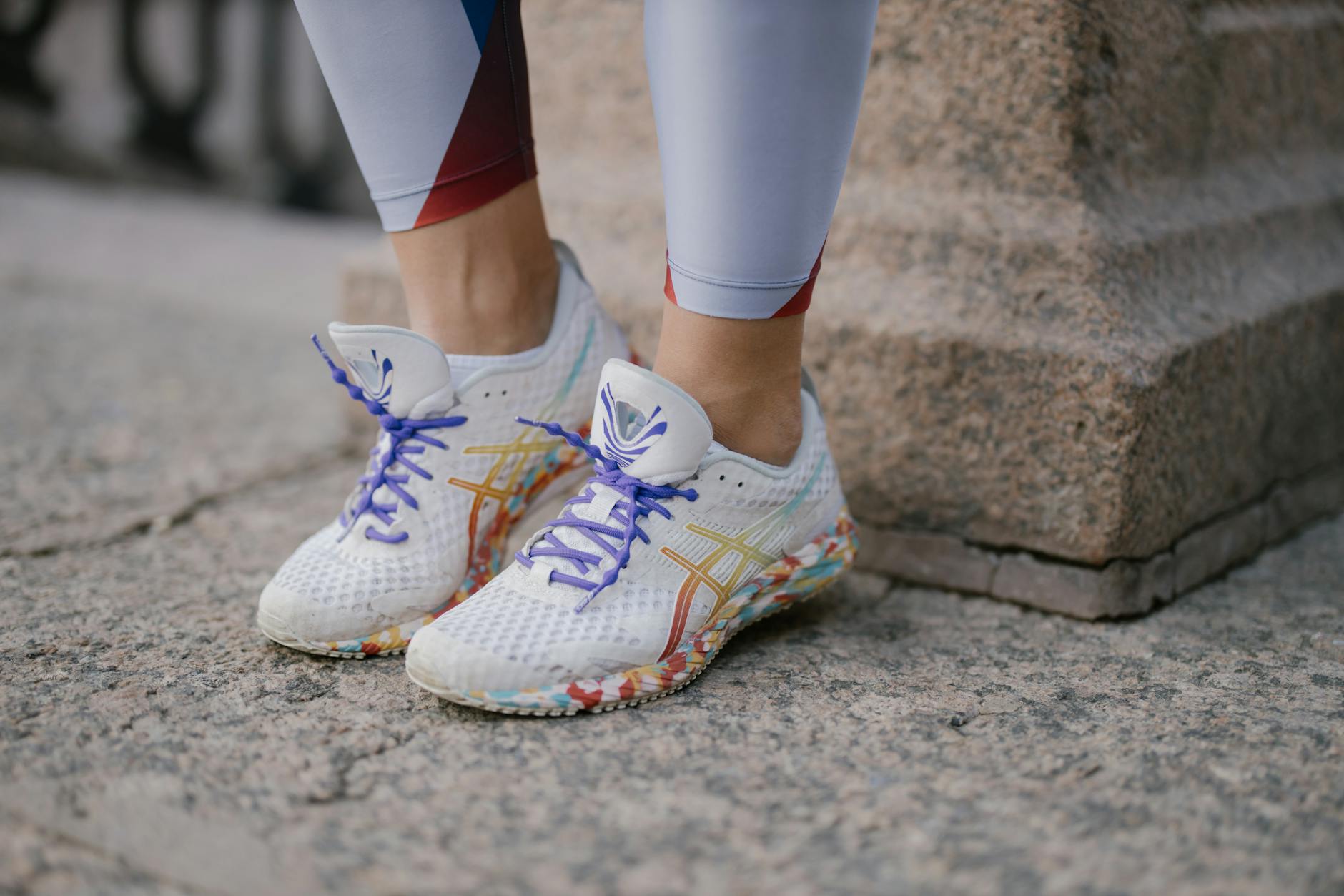 White athletic sneakers with colorful pattern on a concrete surface. - best running shoes