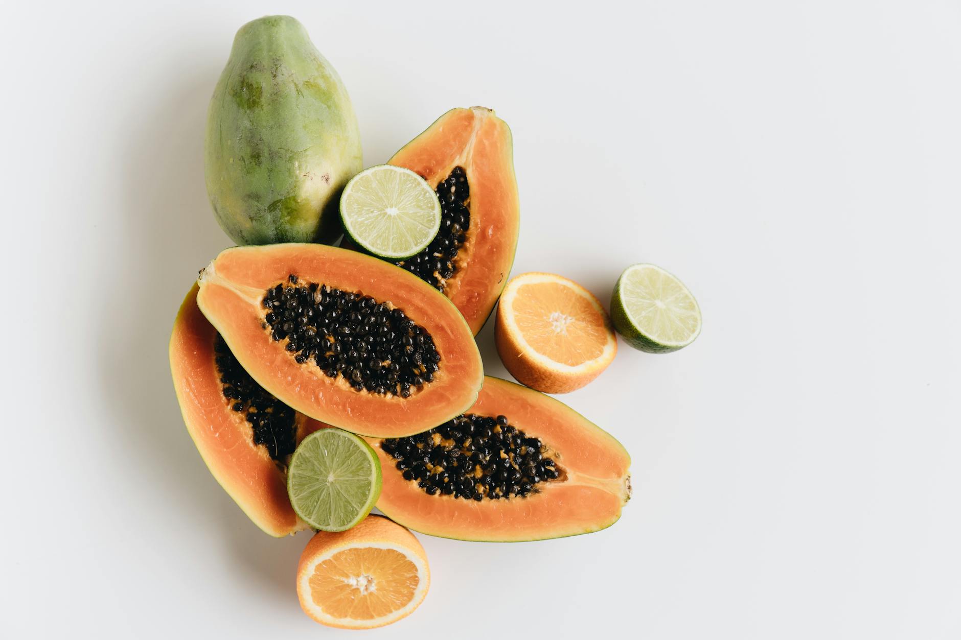 Top view of vibrant papaya, lime, and orange slices showcasing freshness - boost metabolism foods