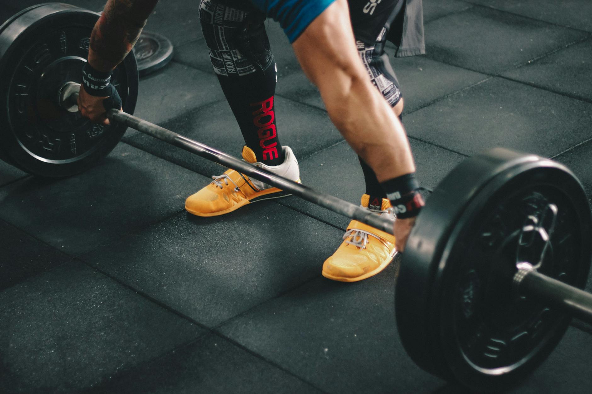 Close-up photo of a man lifting a barbell in the gym, showcasing strength and fitness. - creatine benefits