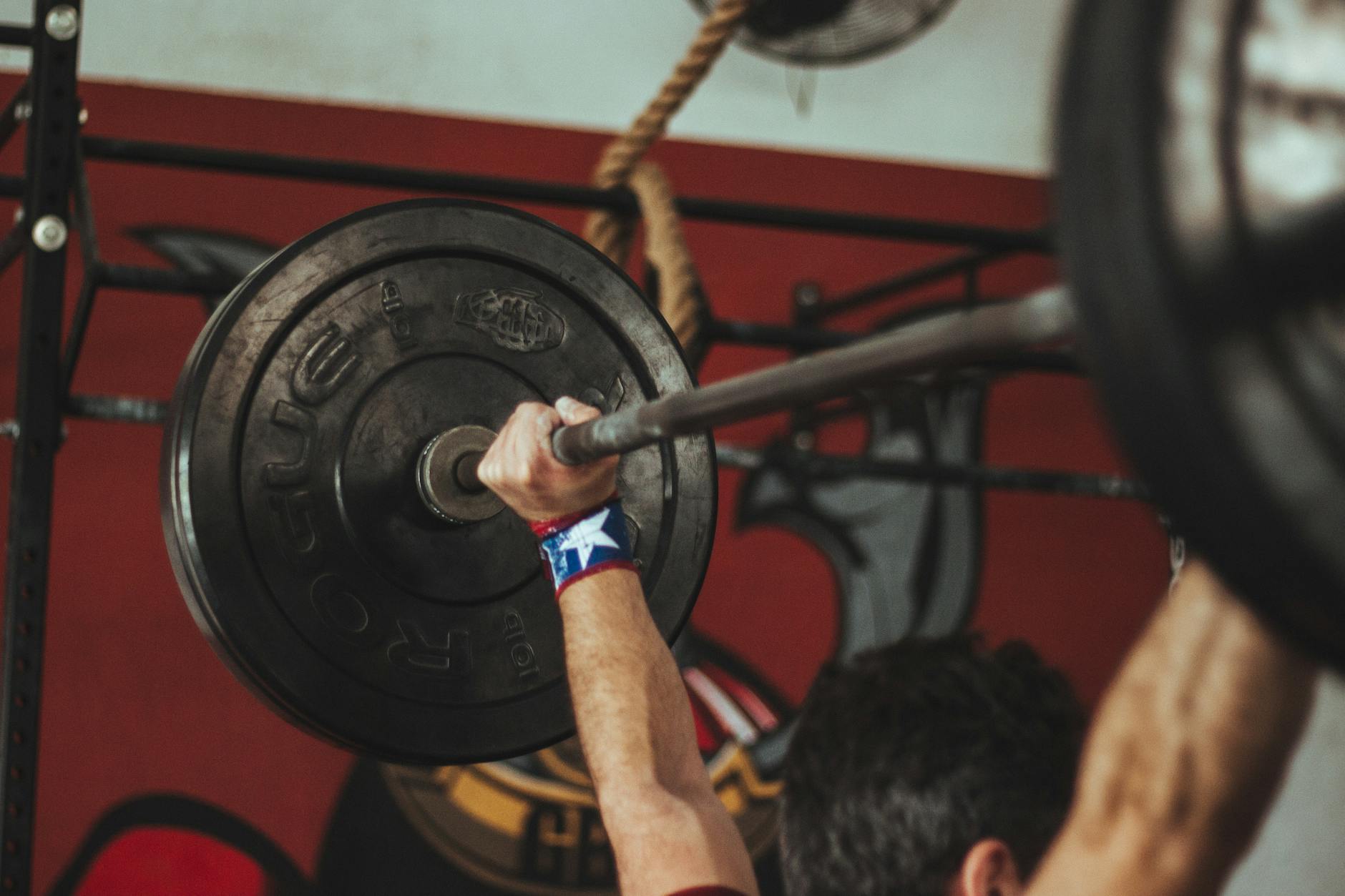 Athlete lifting heavy barbell during strength training session in gym. - creatine benefits
