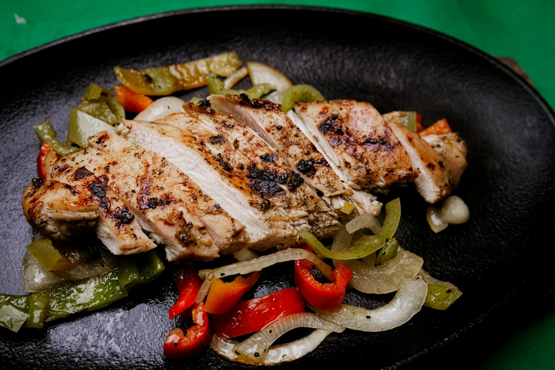Succulent grilled chicken with vibrant peppers on a sizzling plate, perfect for a tasty meal. - healthy casserole recipes