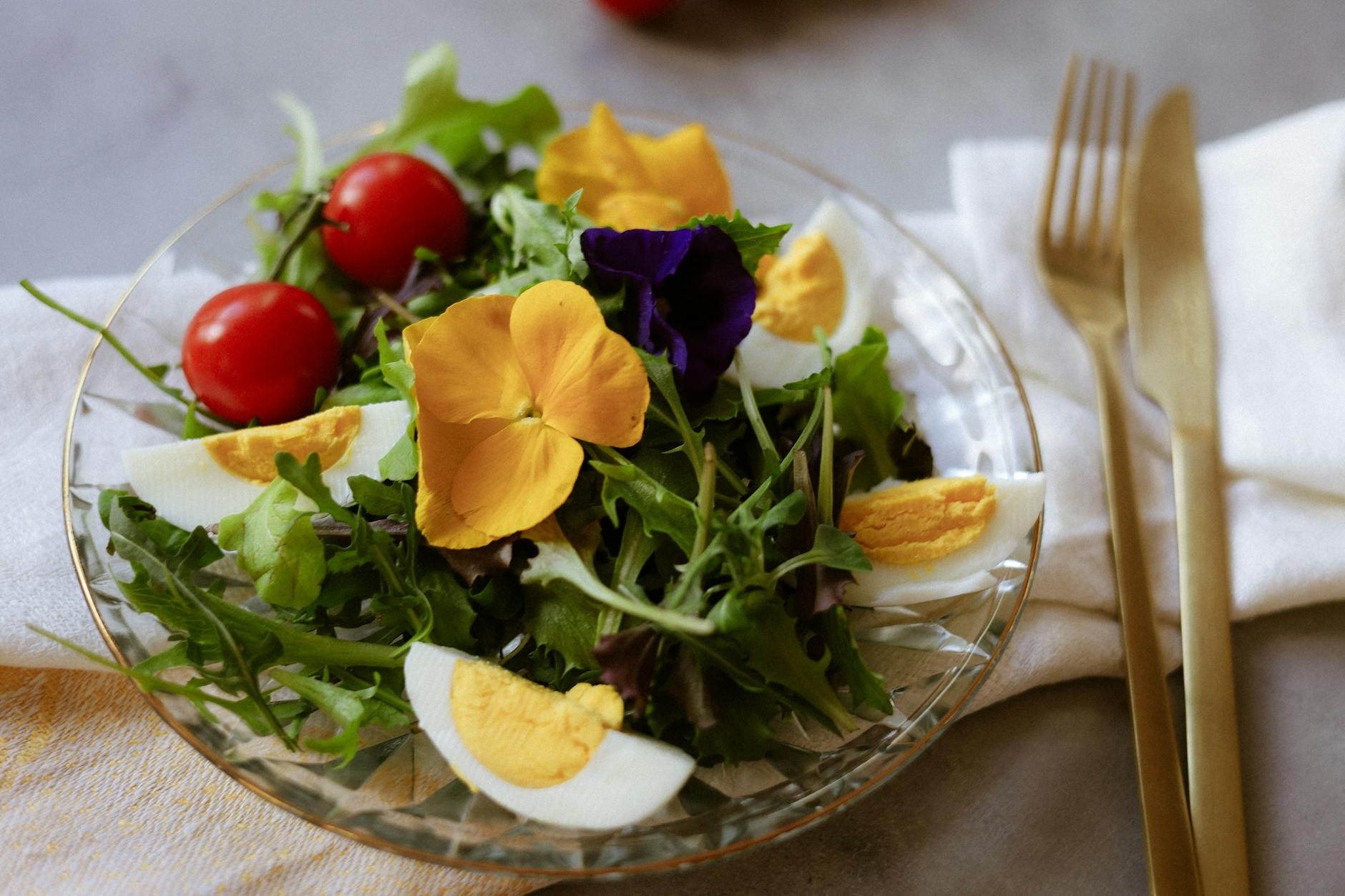 Healthy salad featuring edible flowers, cherry tomatoes, and hard-boiled eggs. - healthy spring salads
