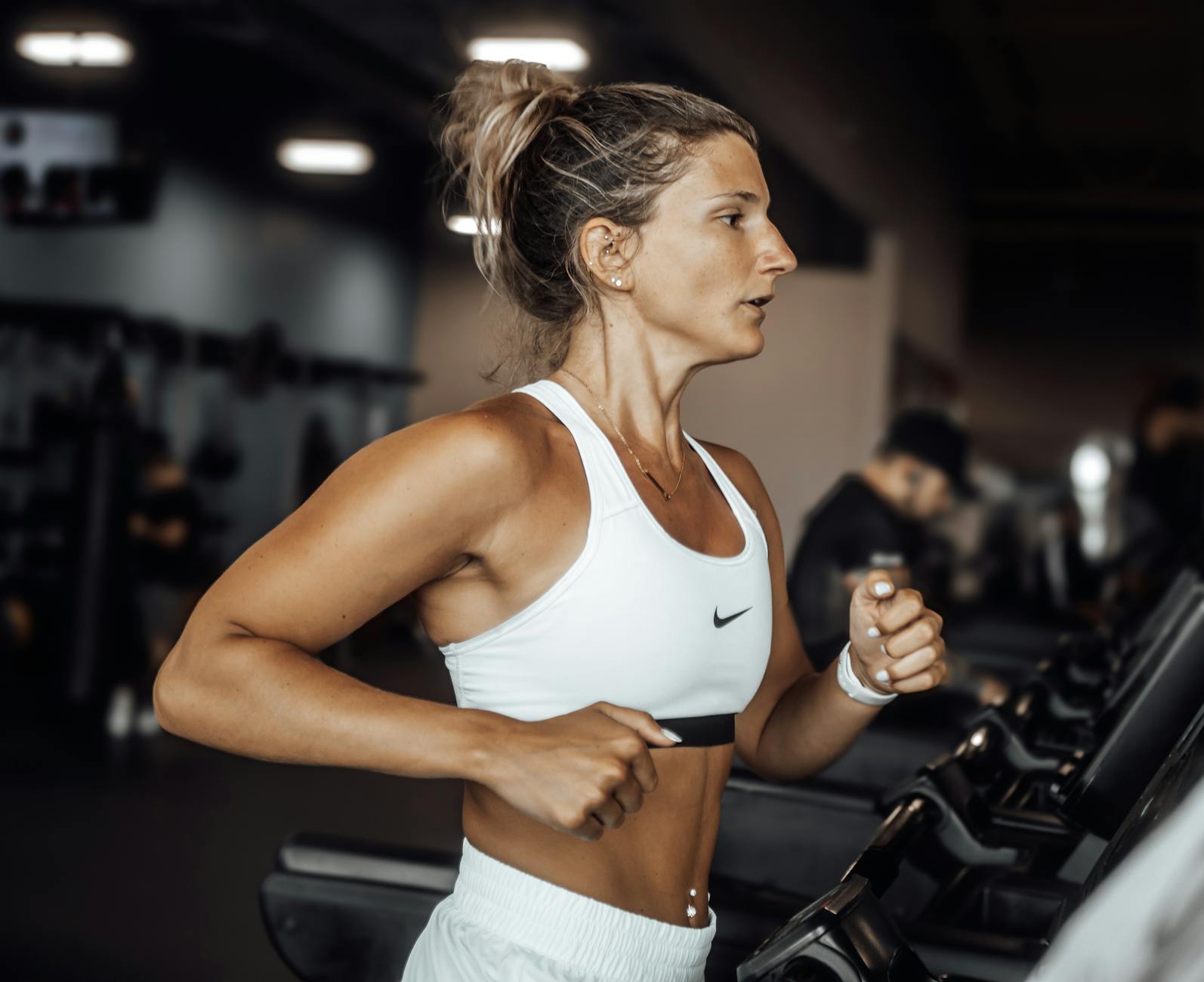 Fit woman exercising on a treadmill in a modern gym setting. - interval training cardio