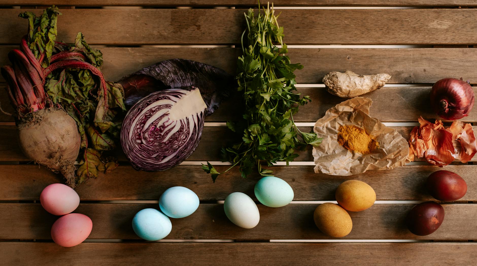 An arrangement of colorful eggs and fresh vegetables on a wooden table. Perfect for culinary or seasonal themes. - mindful spring eating