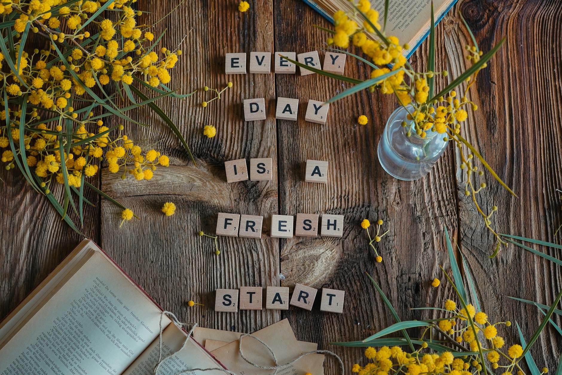 Flat lay of rustic wood, yellow flowers, and motivational quote. - mindfulness for fresh start