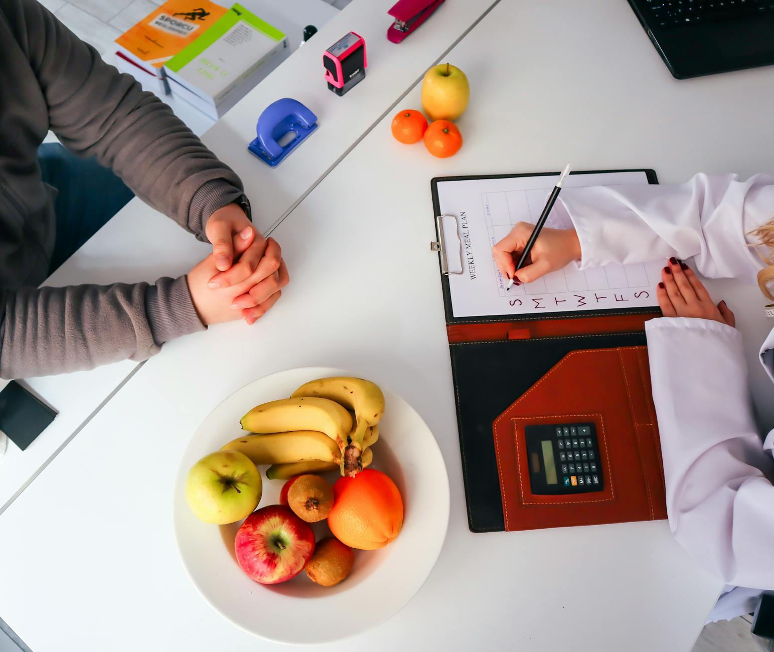 Top view of a dietitian planning a healthy diet with fresh fruits on the table, focusing on health and nutrition. - optimal nutrition guide