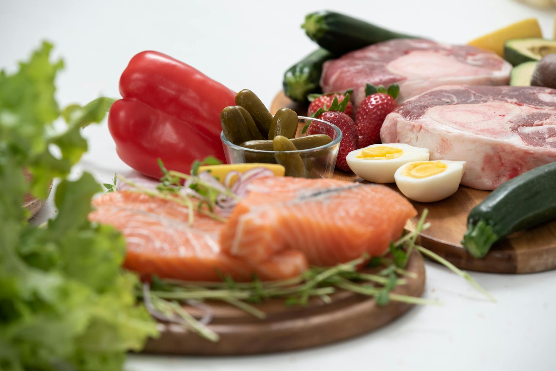A vibrant assortment of fresh salmon, eggs, vegetables, and fruits arranged on a wooden platter. - raw food nutrition