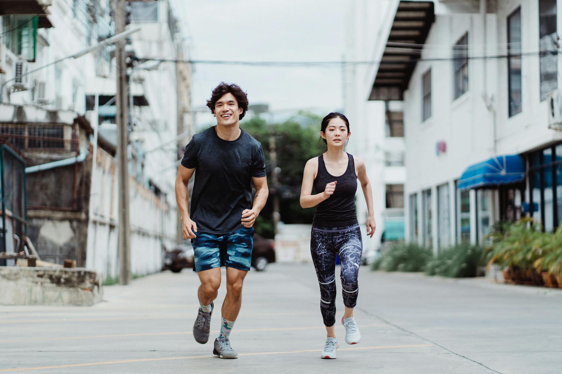 Energetic couple jogging outdoors in casual activewear in an urban environment, showcasing fitness and lifestyle. - running plan for beginners