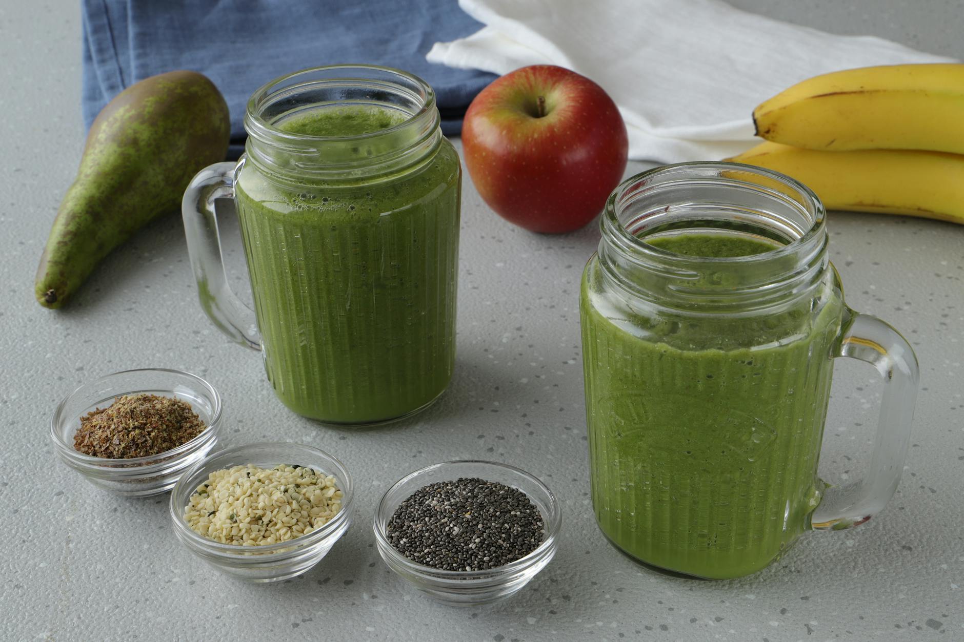 A nutritious green smoothie with apple, pear, and seeds in a cozy kitchen setting. - spring energy smoothie