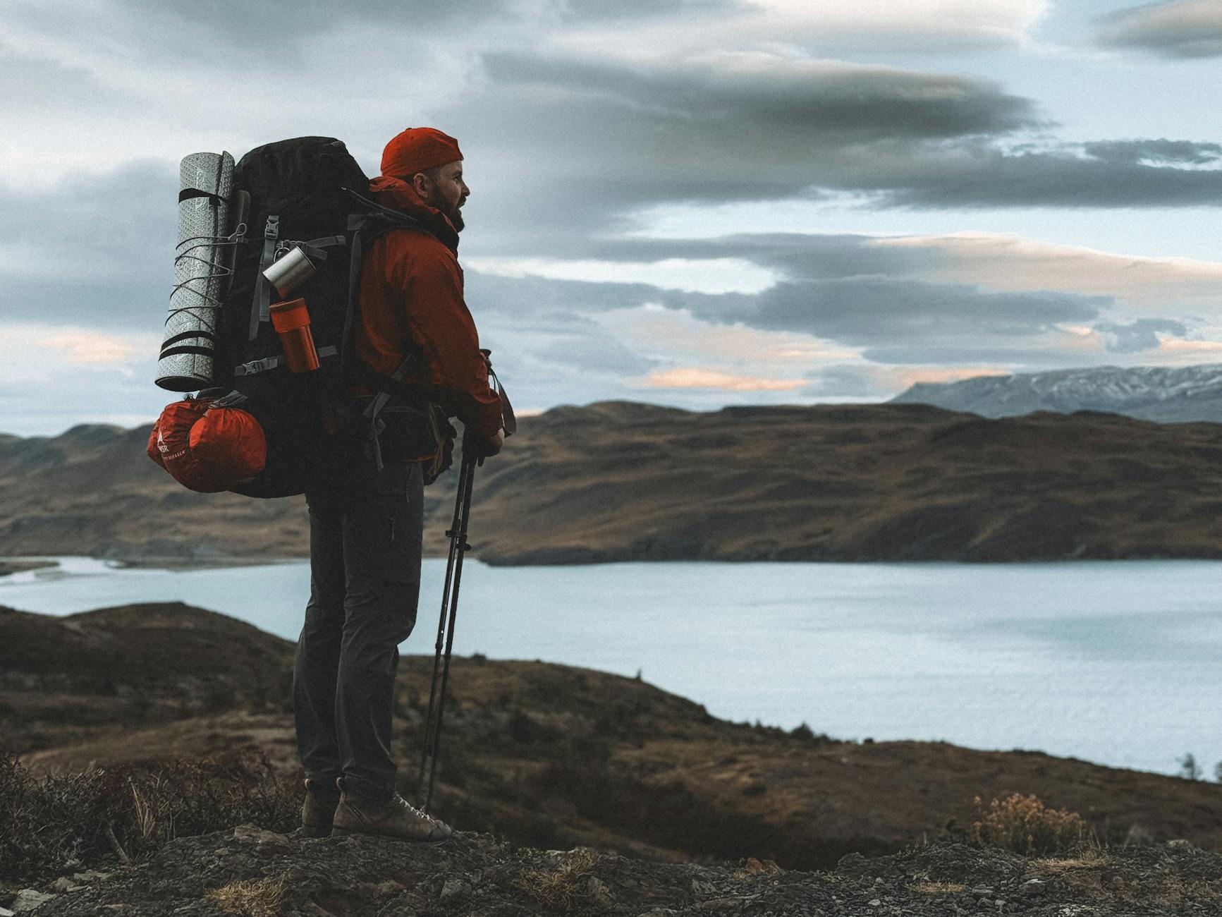 A lone hiker in Patagonia, Chile, enjoying the scenic outdoors by a tranquil lake. - spring hiking gear