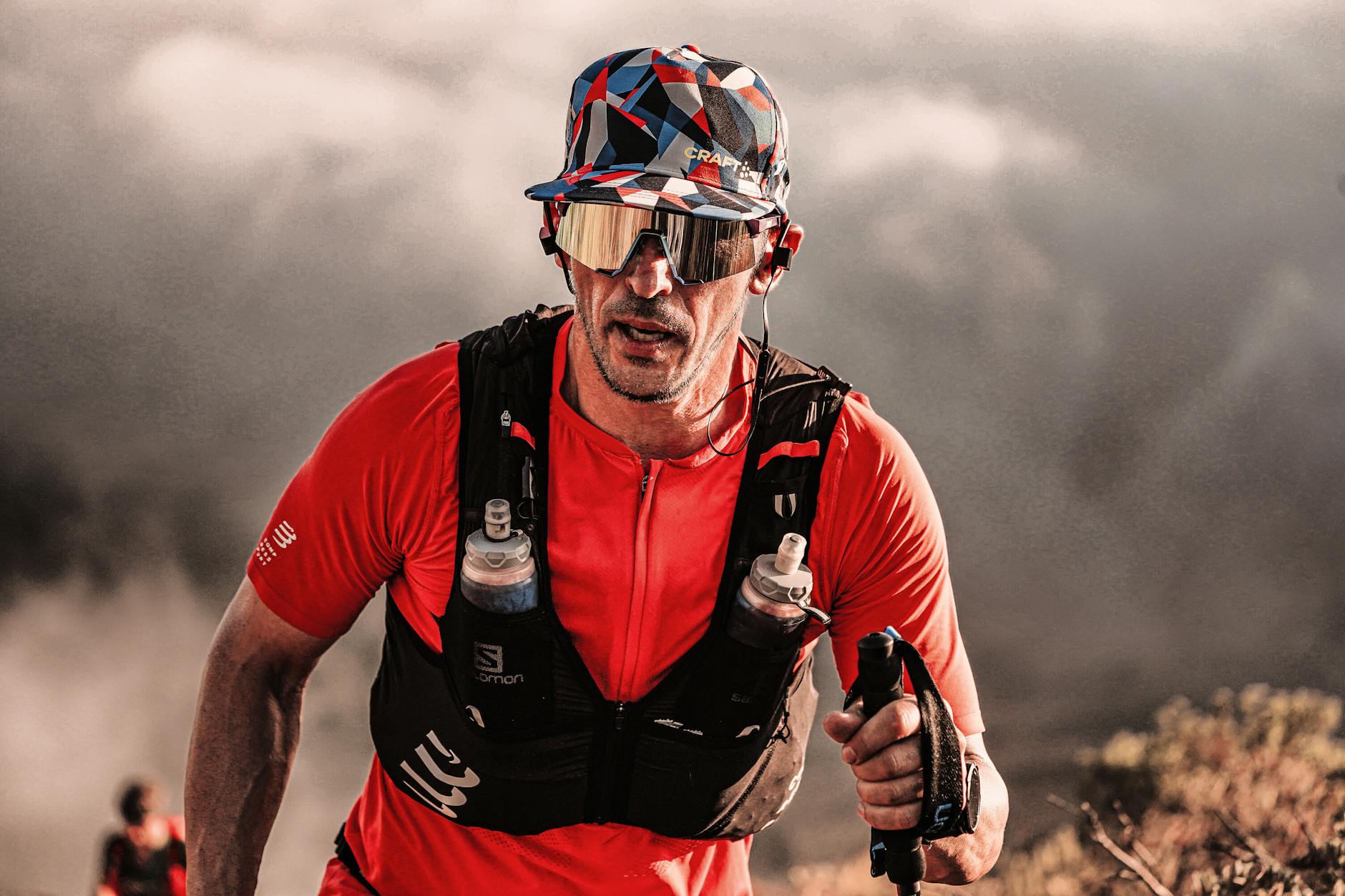 Focused runner in red sportswear conquering rugged terrain outdoors. - spring hiking running