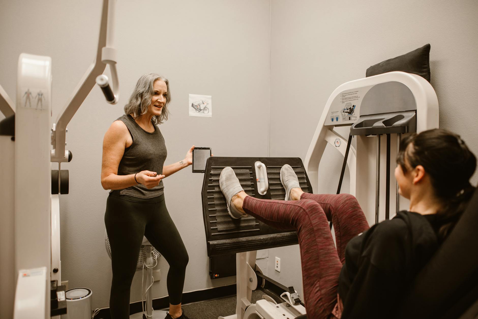 Two women exercising indoors, focusing on health and wellness at a gym. - strength training for women
