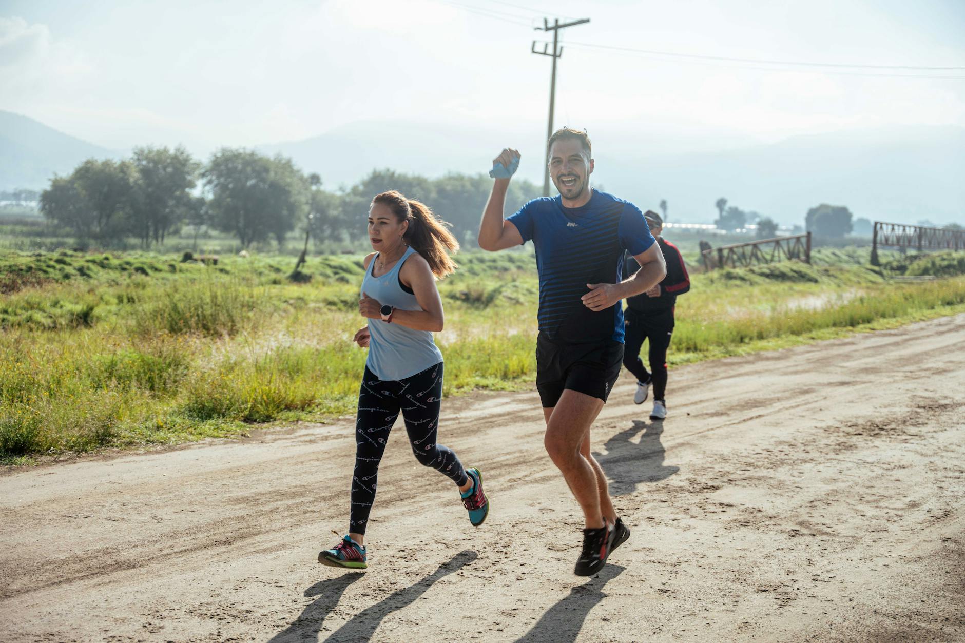 A group of runners enjoys a vibrant morning jog on a rural dirt road. - trail running advanced