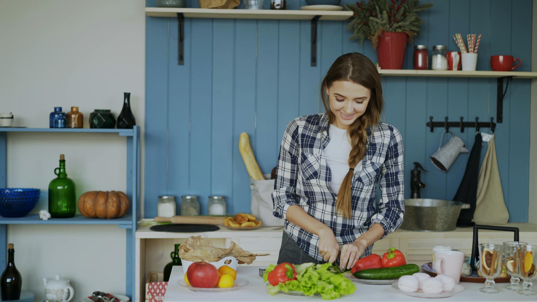 Smiling woman chopping vegetables in a cozy kitchen setting. - vegan spring recipes