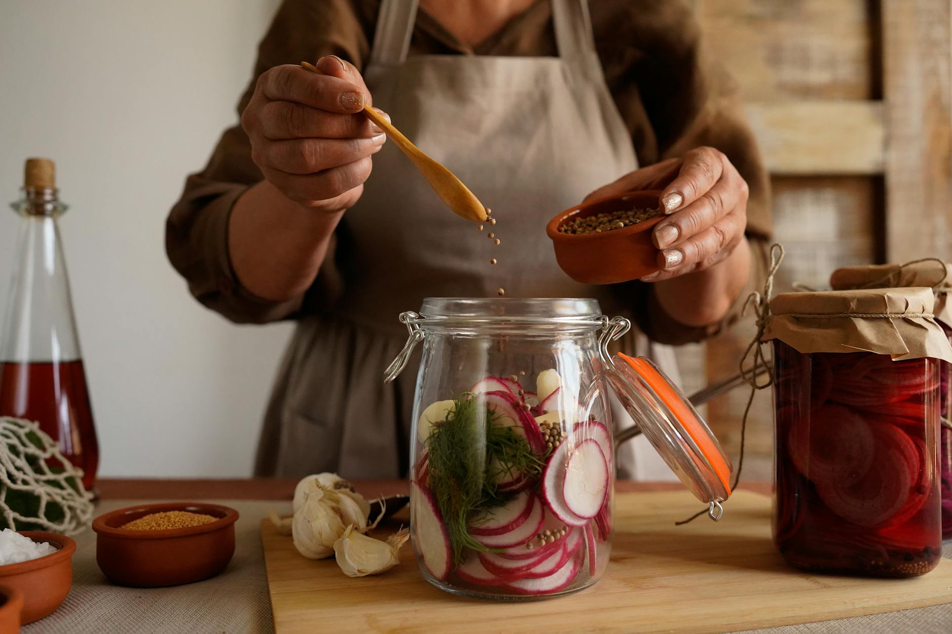 Hands preparing pickled vegetables in a jar, capturing a rustic and organic lifestyle. - benefits of fermented foods