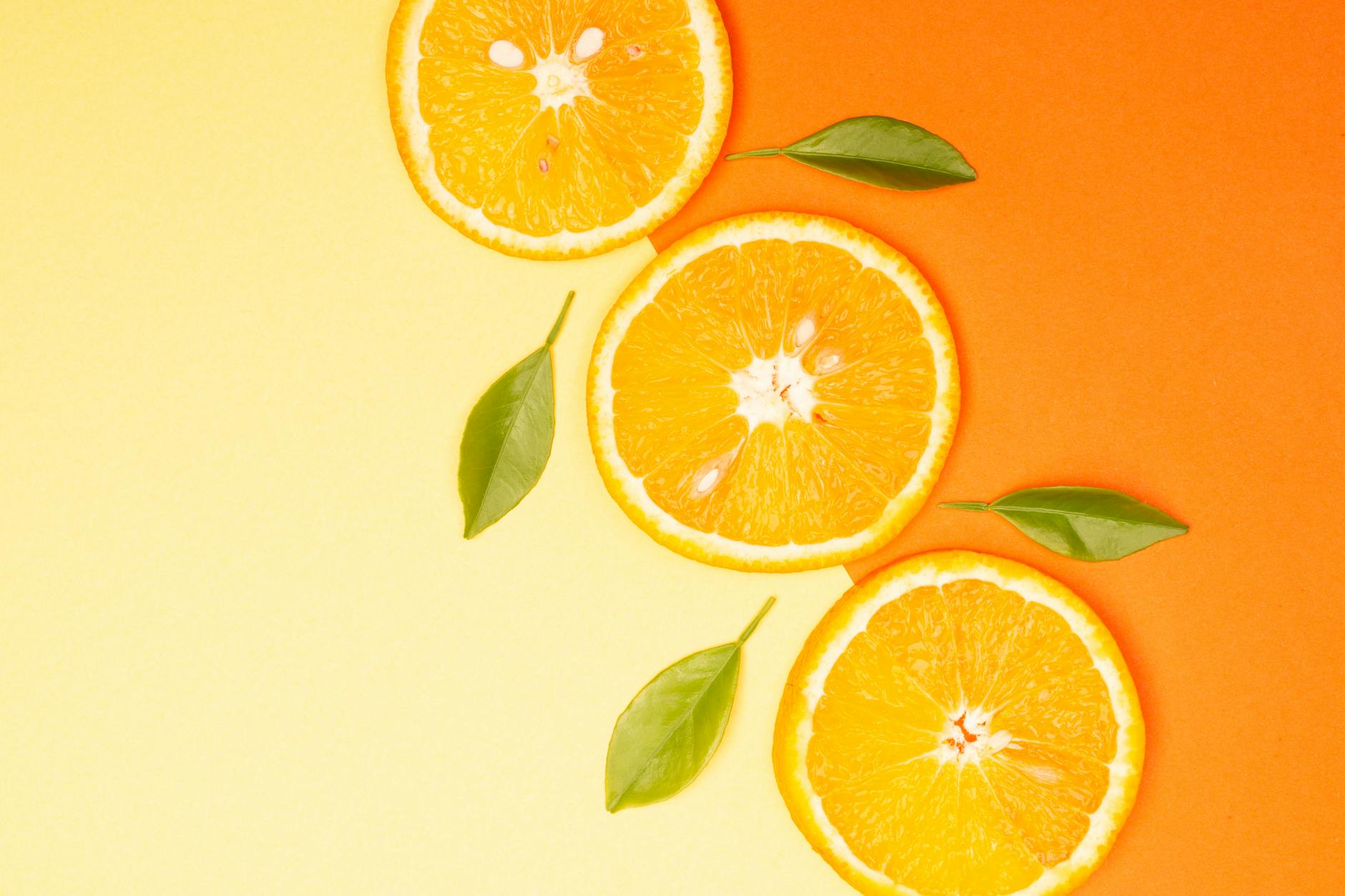 Close-up of fresh orange slices with green leaves on a gradient background. - boost immunity naturally